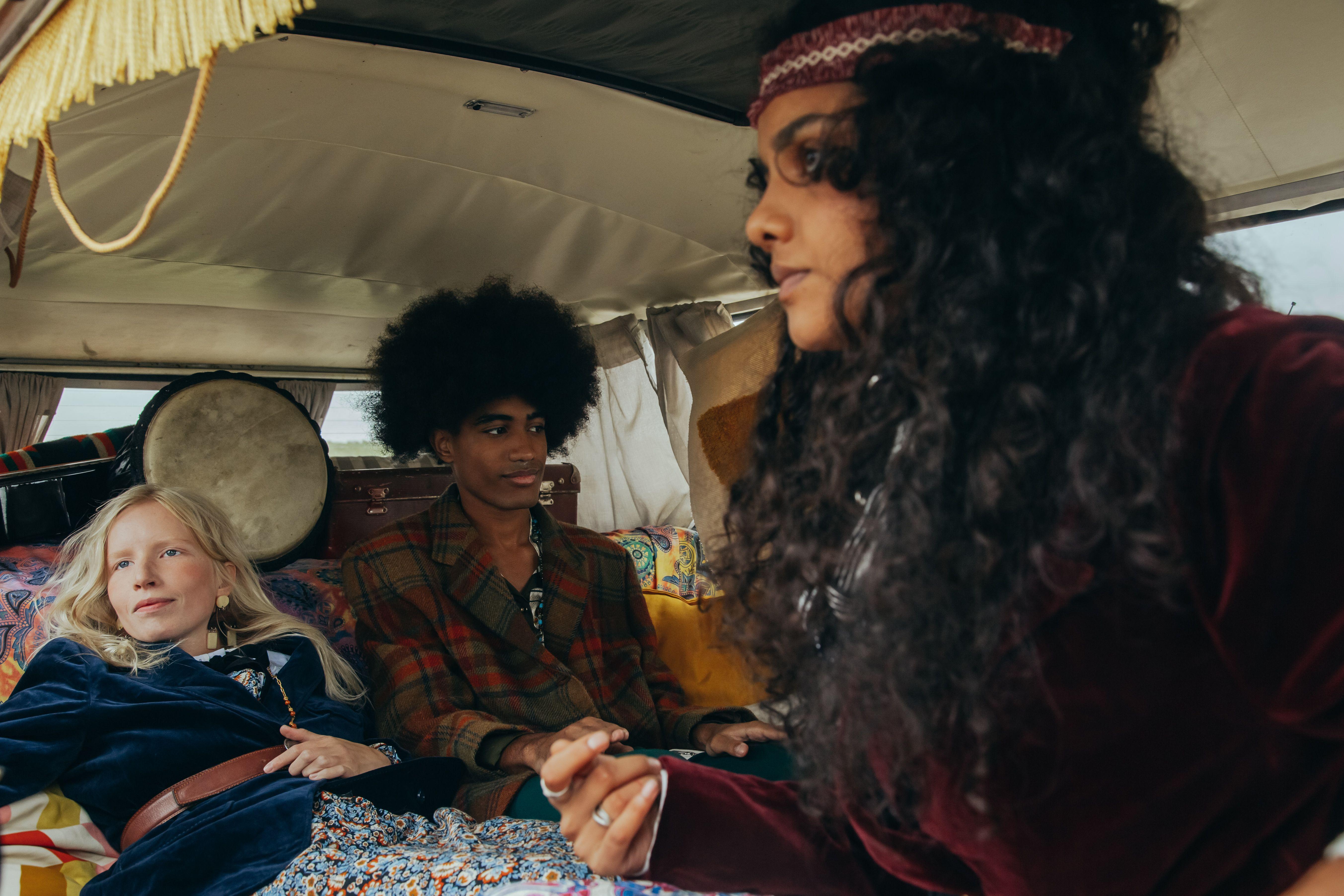 Group of young friends enjoying a retro van ride, embodying vintage style and carefree spirit.