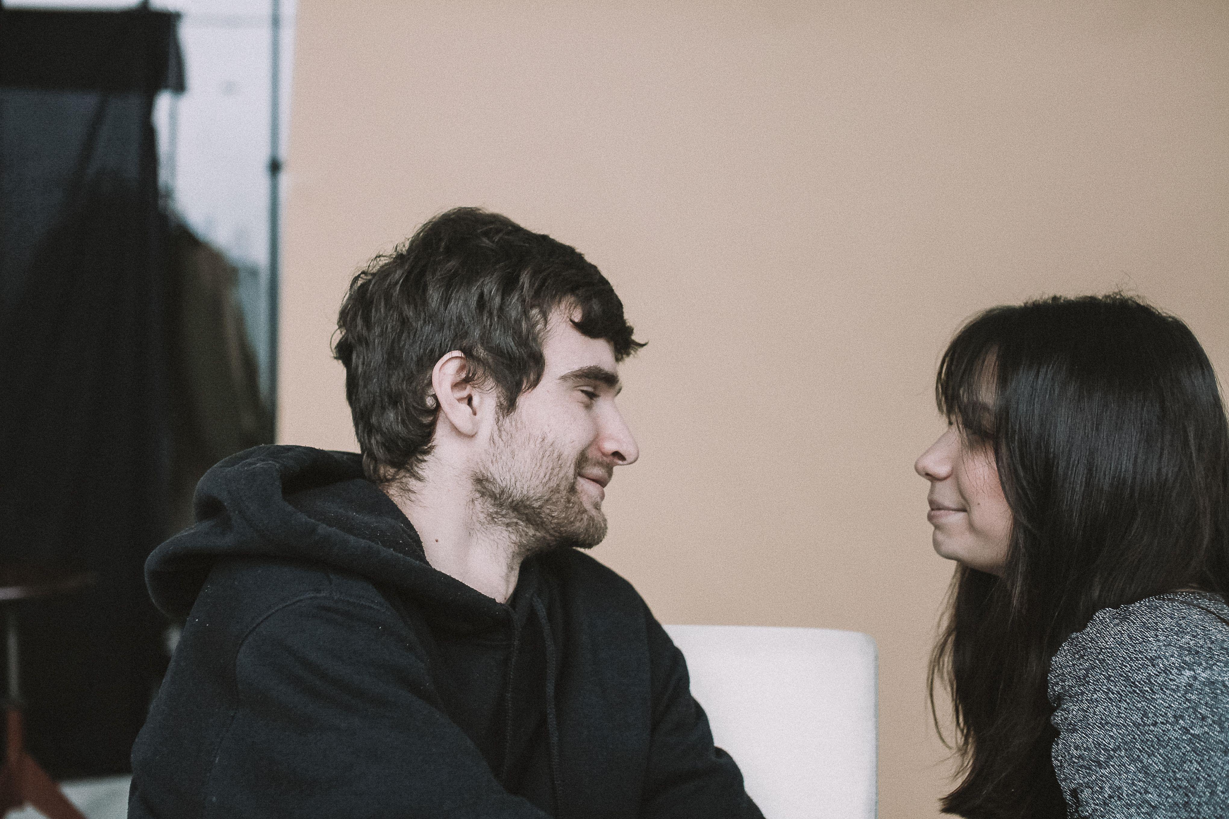 A candid close-up of a happy couple looking at each other with love in a serene indoor setting.