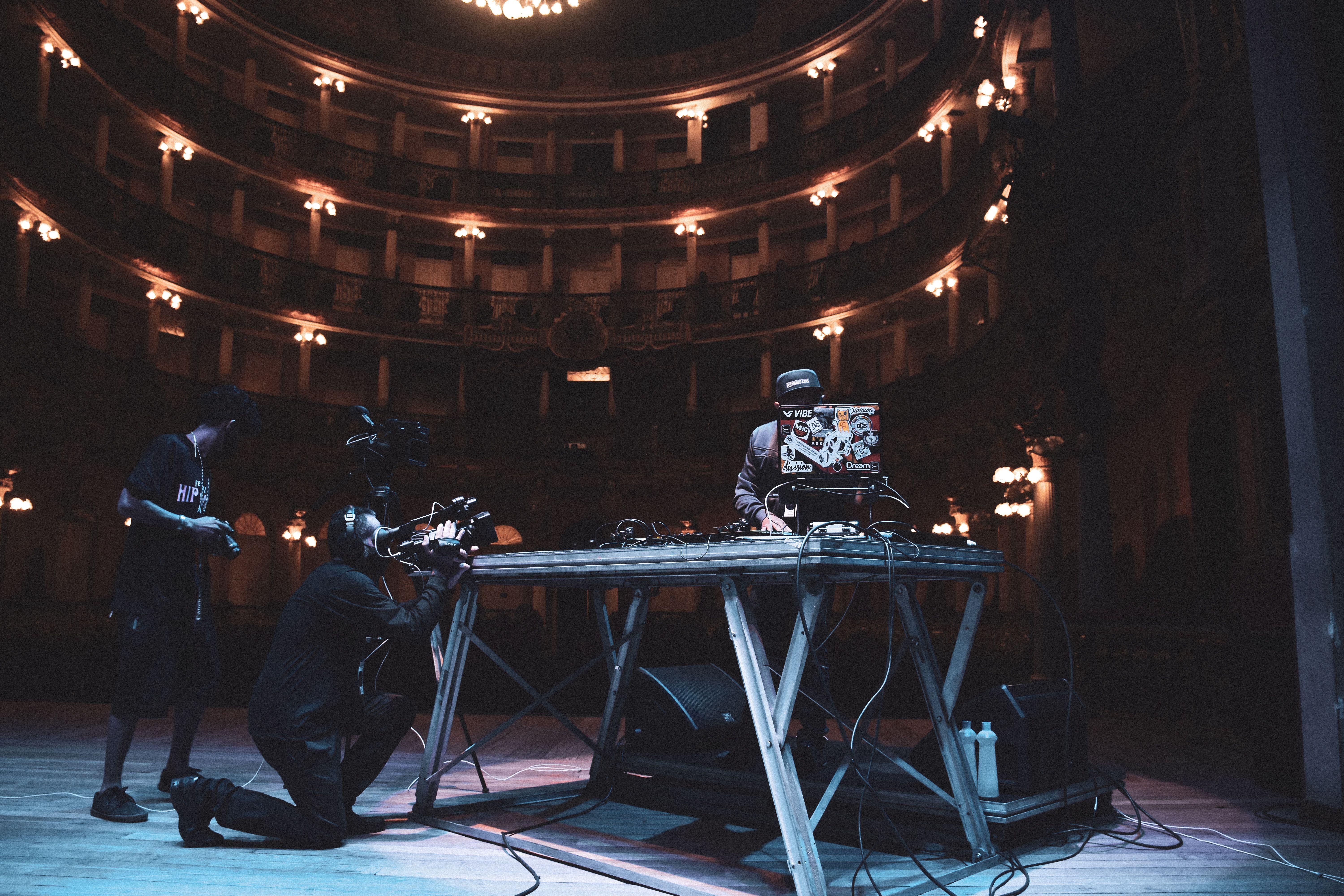 DJ performing with crew in a grand theater in Brazil, capturing the essence of live music and performance.