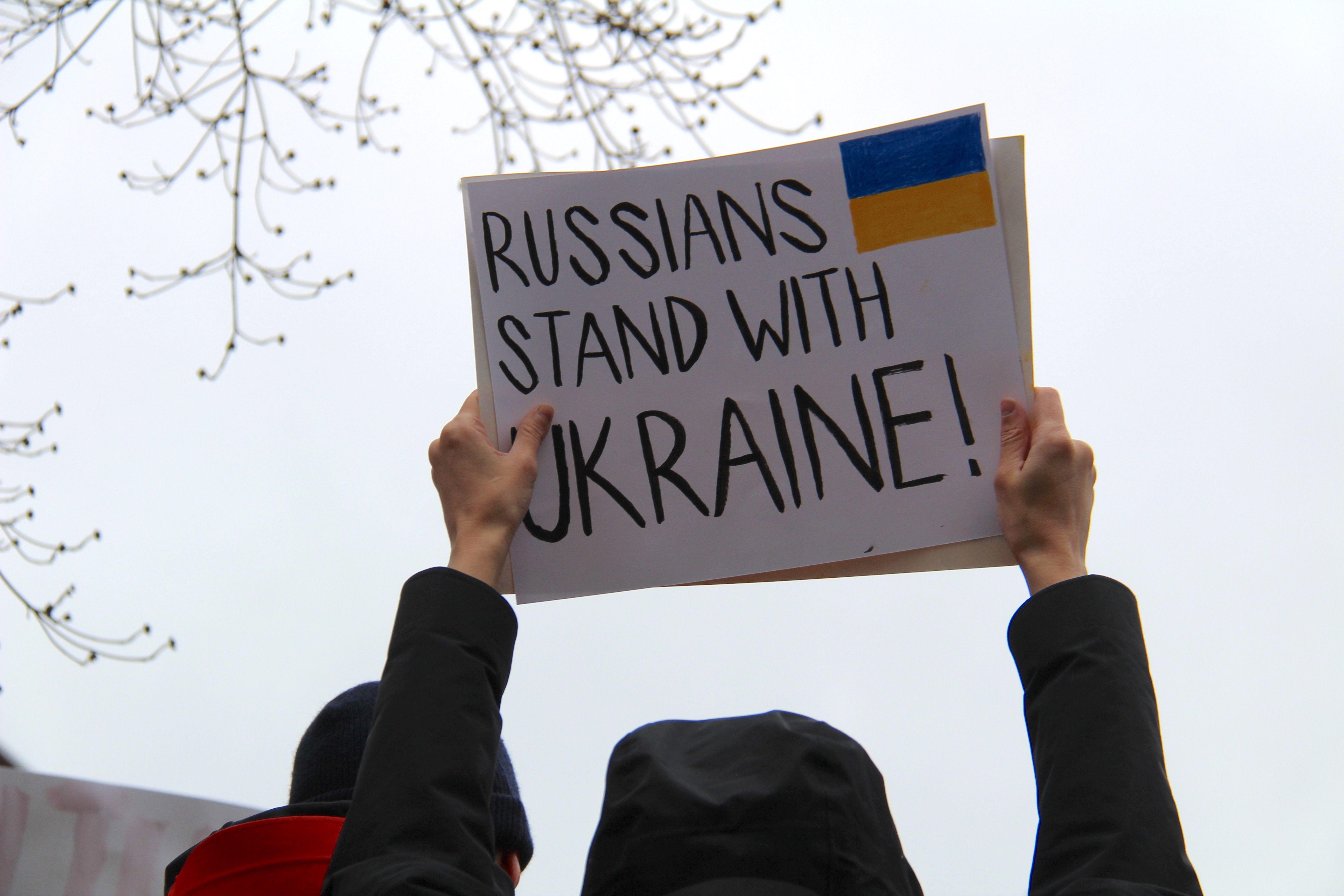 Protesters in Vancouver hold signs supporting Ukraine against Russian actions.