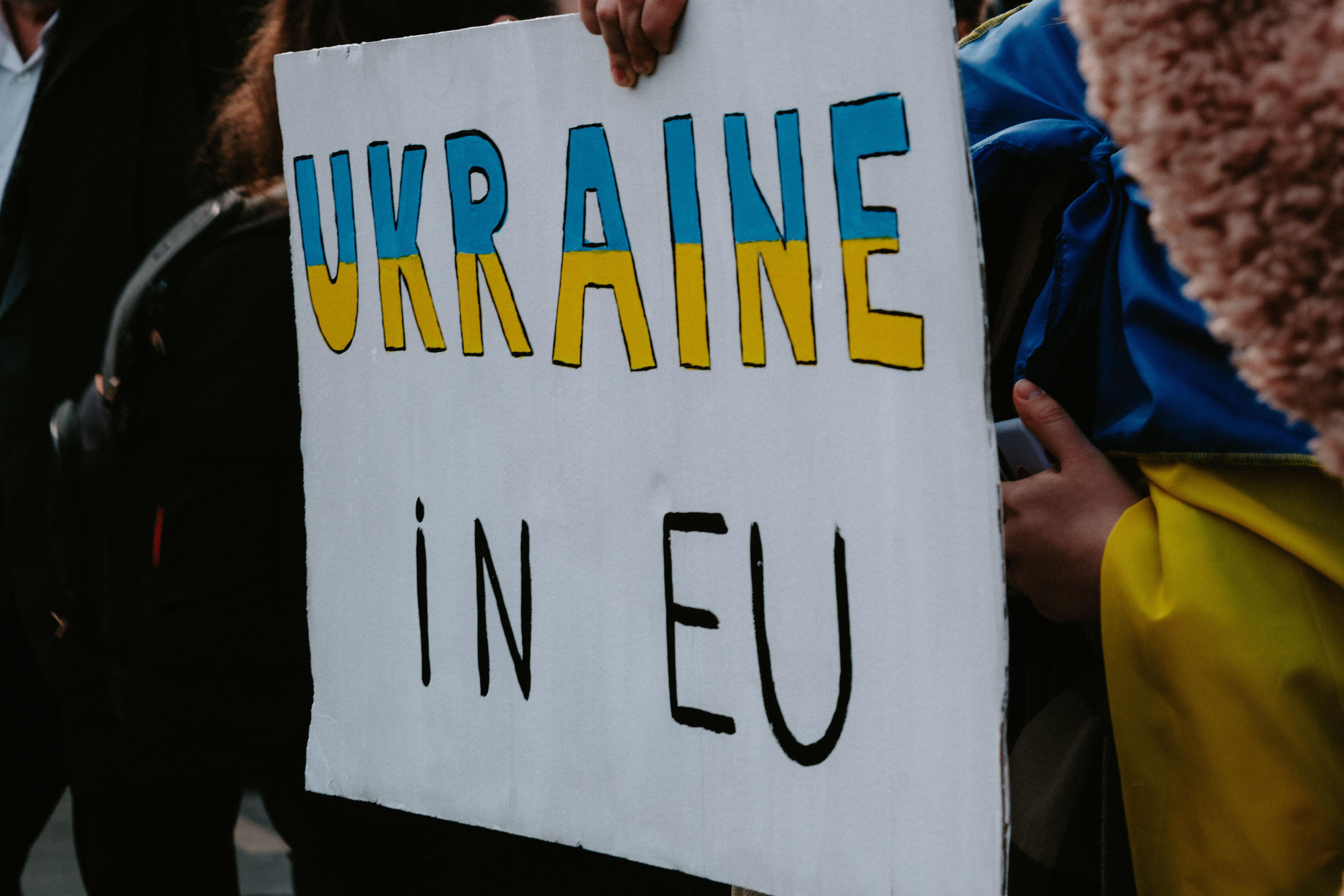 A protest sign advocating Ukraine's membership in the EU, held by demonstrators outdoors.