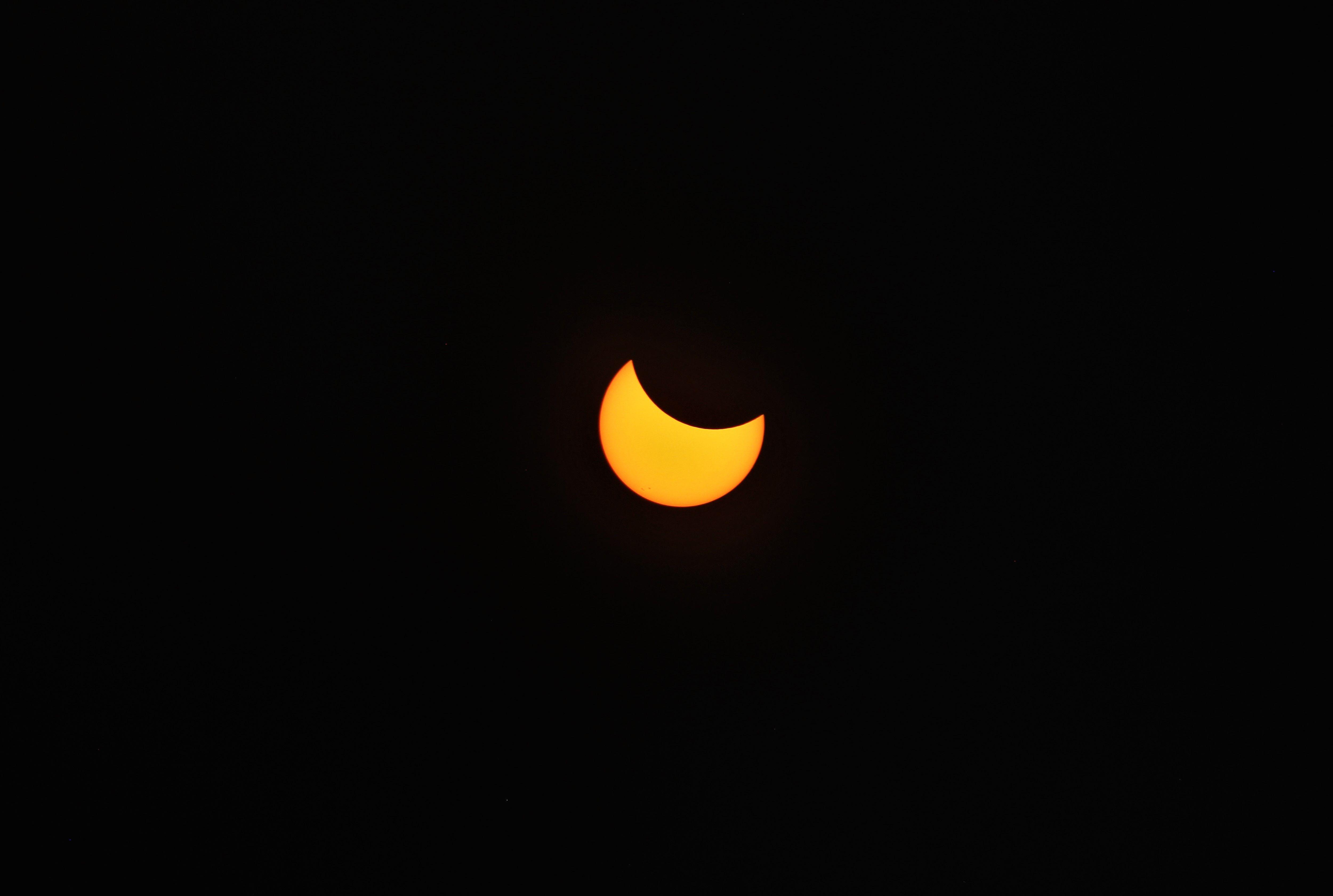 A stunning view of a partial solar eclipse captured against a pitch-black sky.