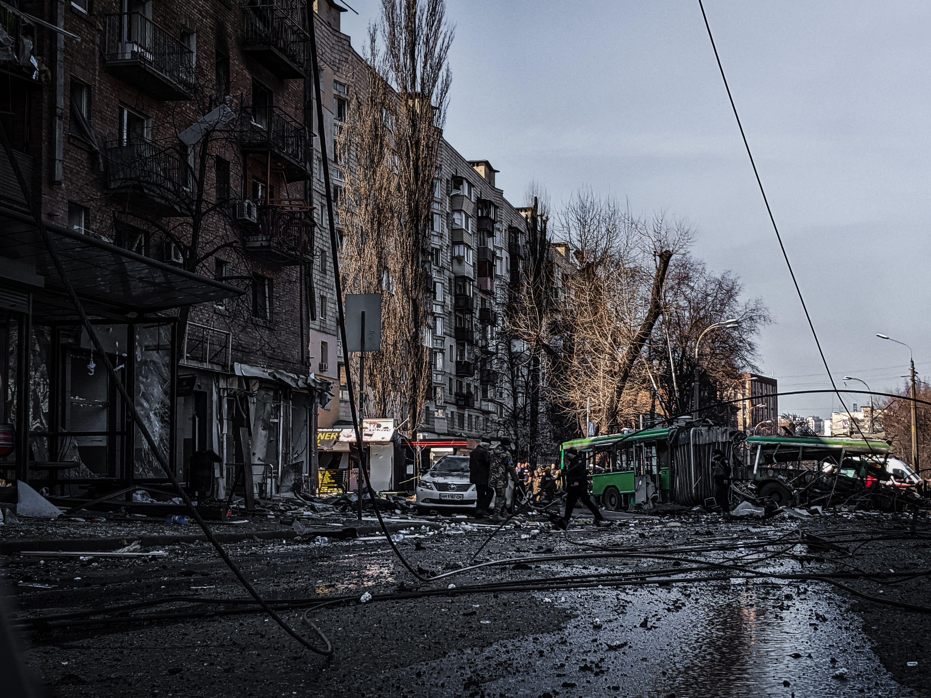 A war-damaged street in Kyiv, Ukraine, showing destruction and chaos.