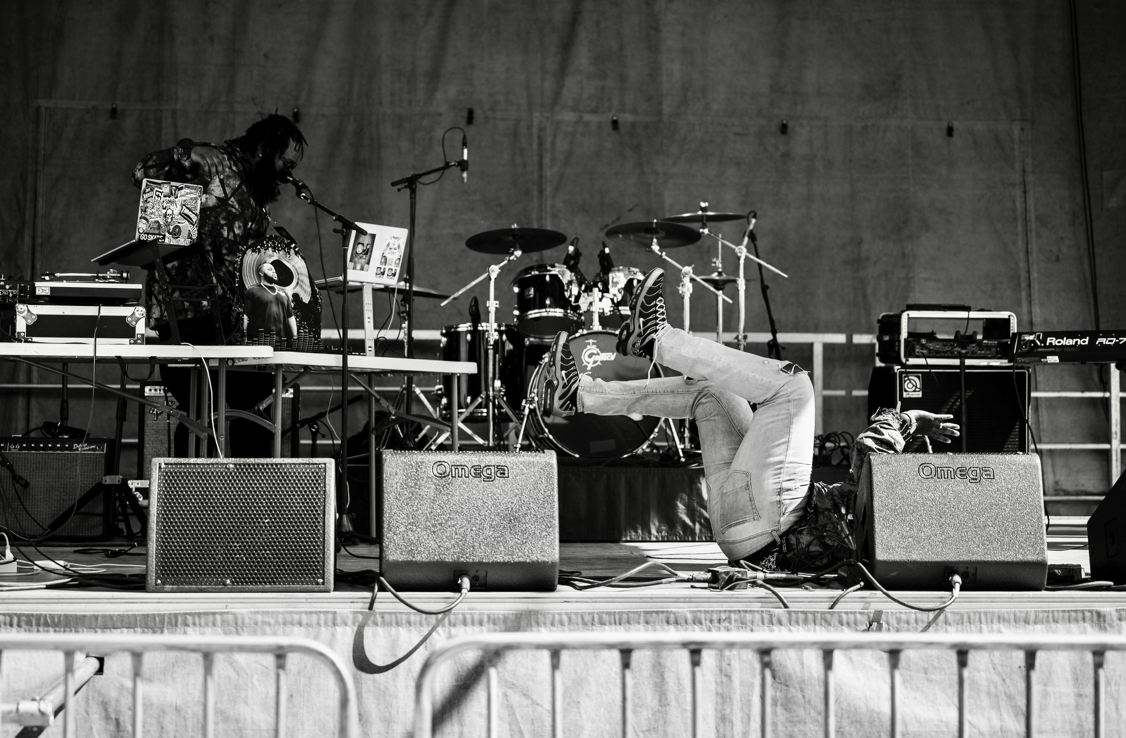 Dynamic monochrome image capturing a live stage performance with musicians and equipment.