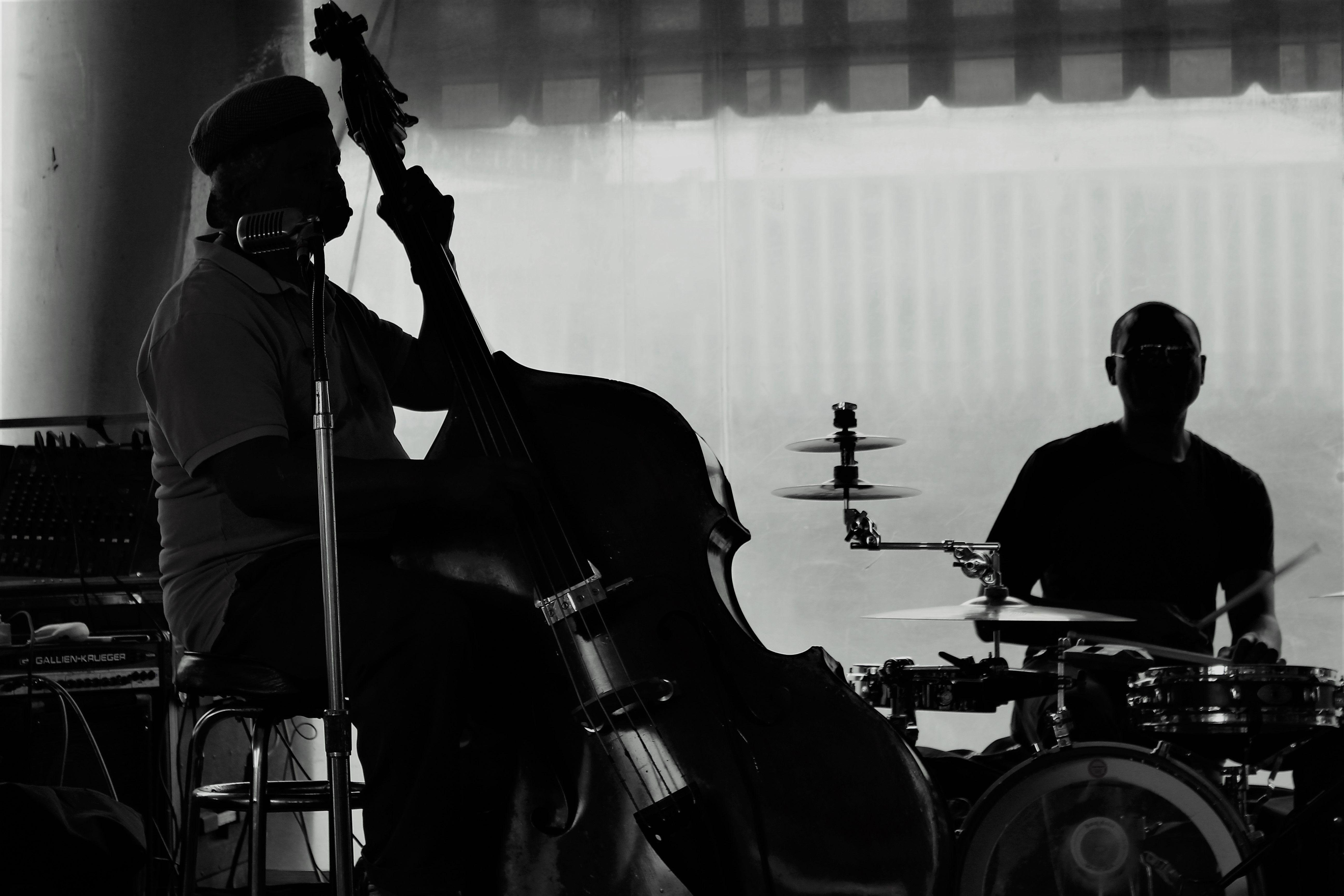 Silhouette of bass and drum musicians performing live jazz music.