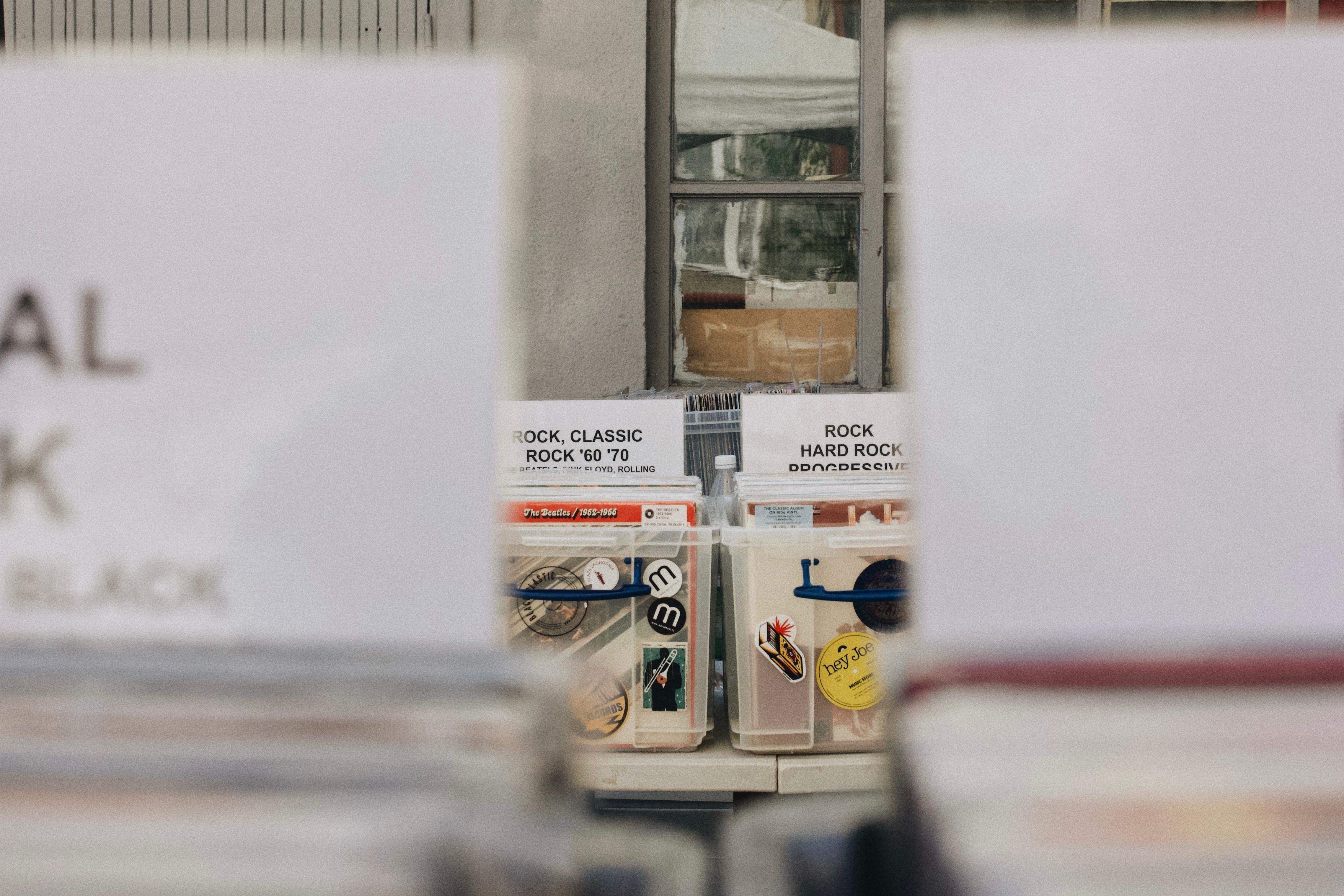 A collection of classic rock vinyl records displayed in plastic containers at an outdoor market in Poland.