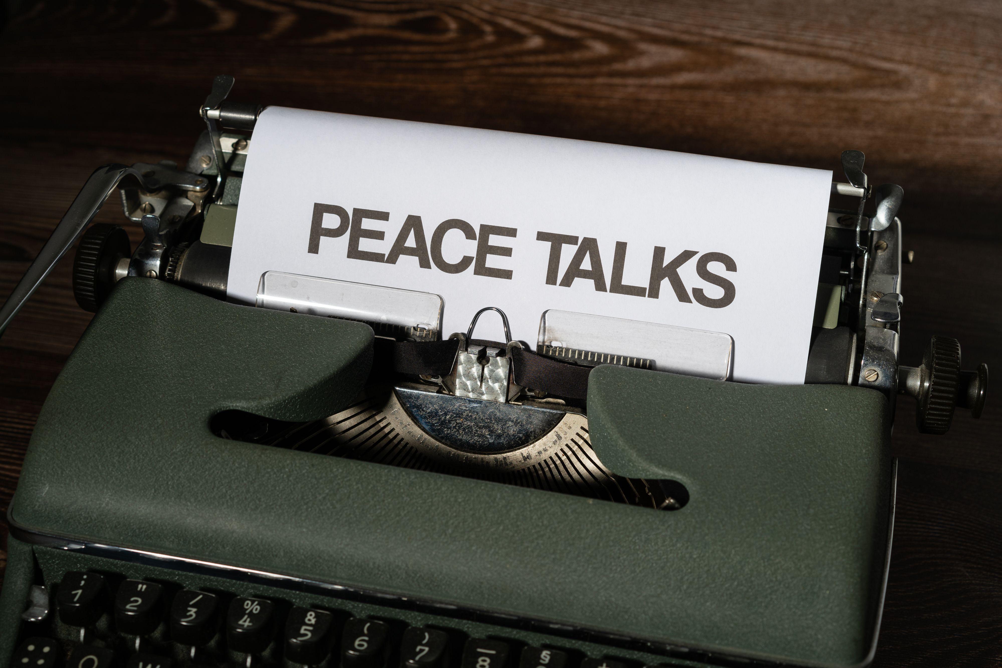 A classic typewriter displays the words 'Peace Talks', symbolizing communication and diplomacy.