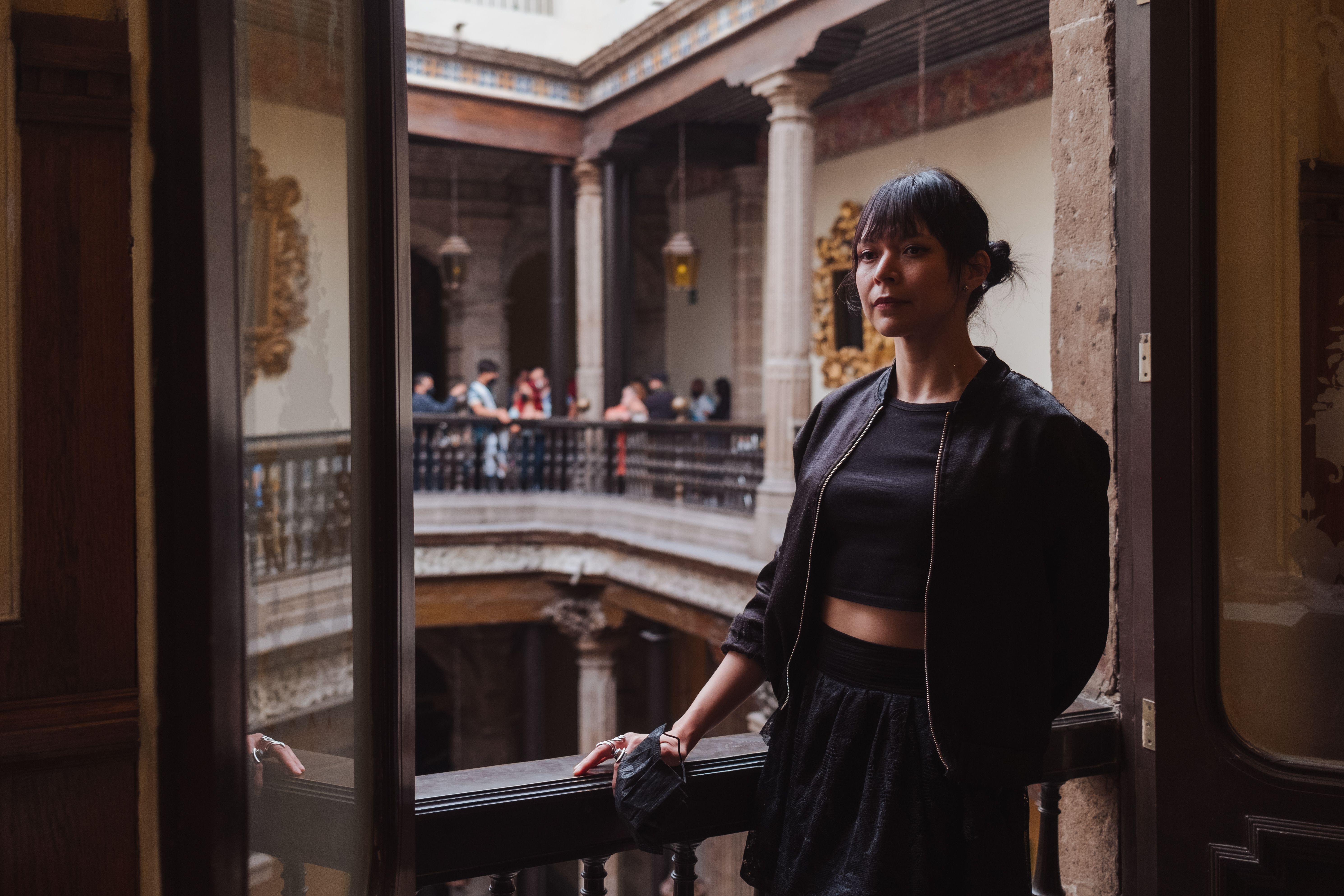 A young woman poses in a historic building, capturing the essence of cultural architecture and travel.