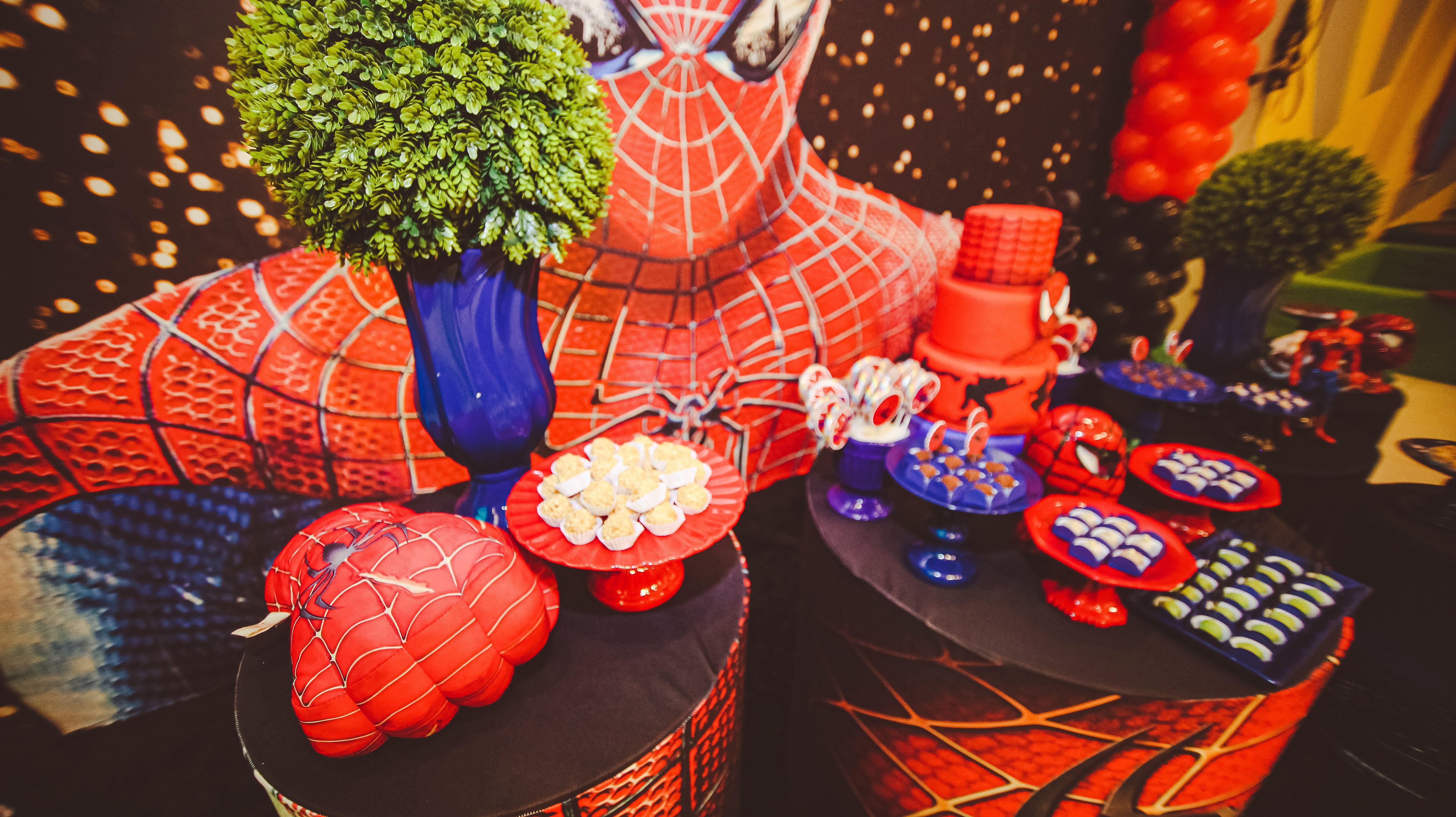 Vibrant Spider-Man themed decorations with cake and desserts for a festive birthday party.