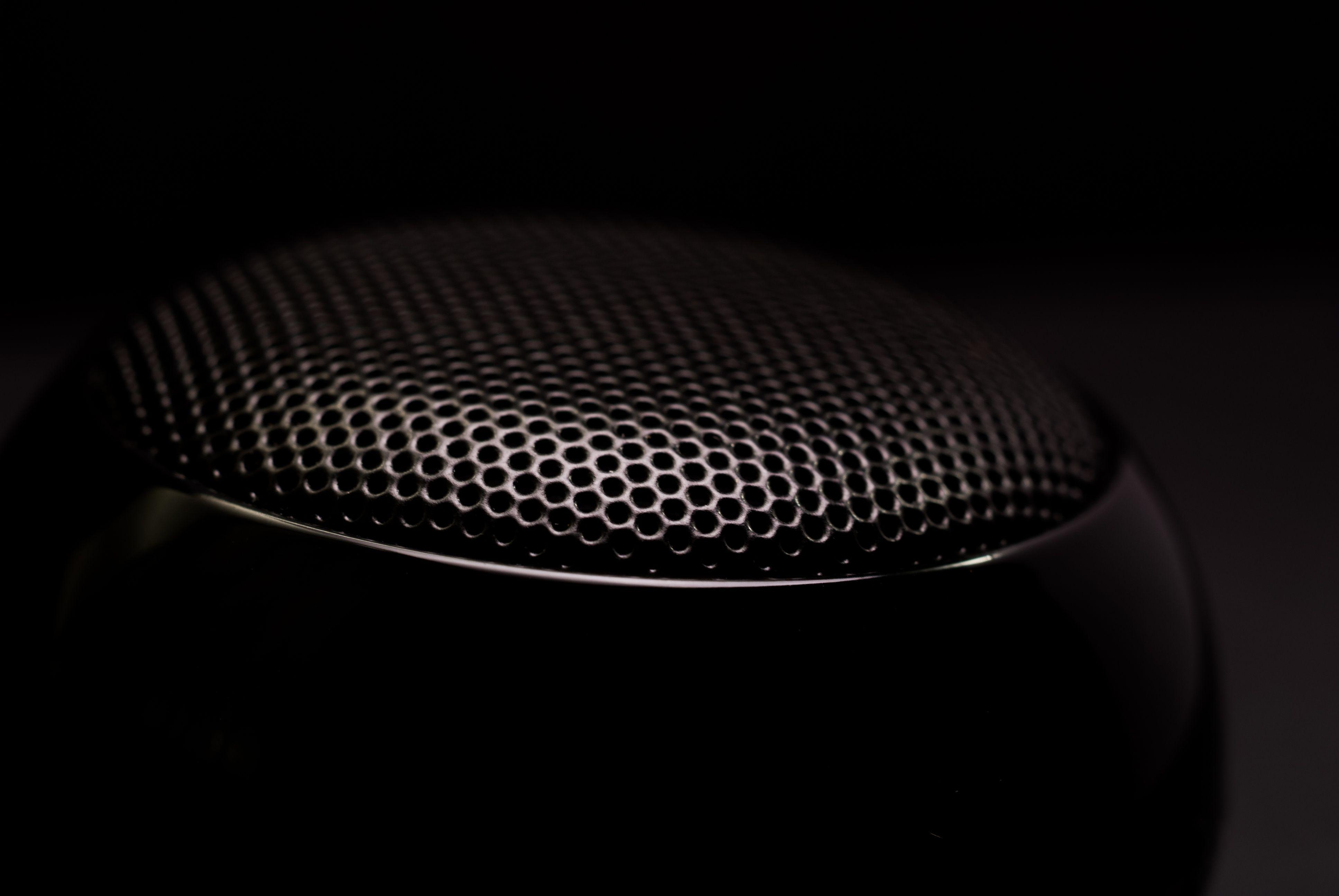 Detailed close-up of a black speaker grill, capturing its sleek and modern design