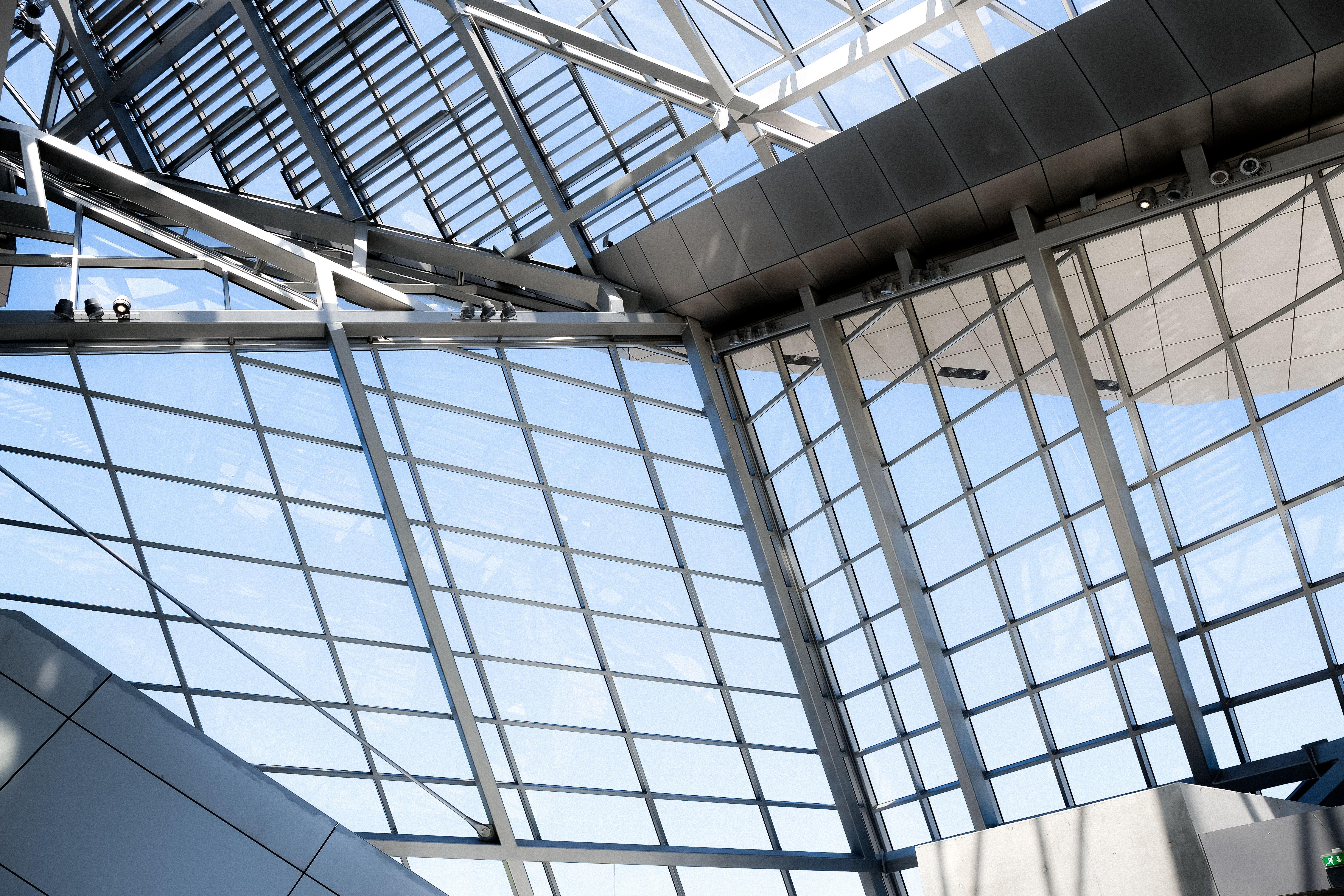 A striking view of a modern glass ceiling with metal frames and natural lighting.