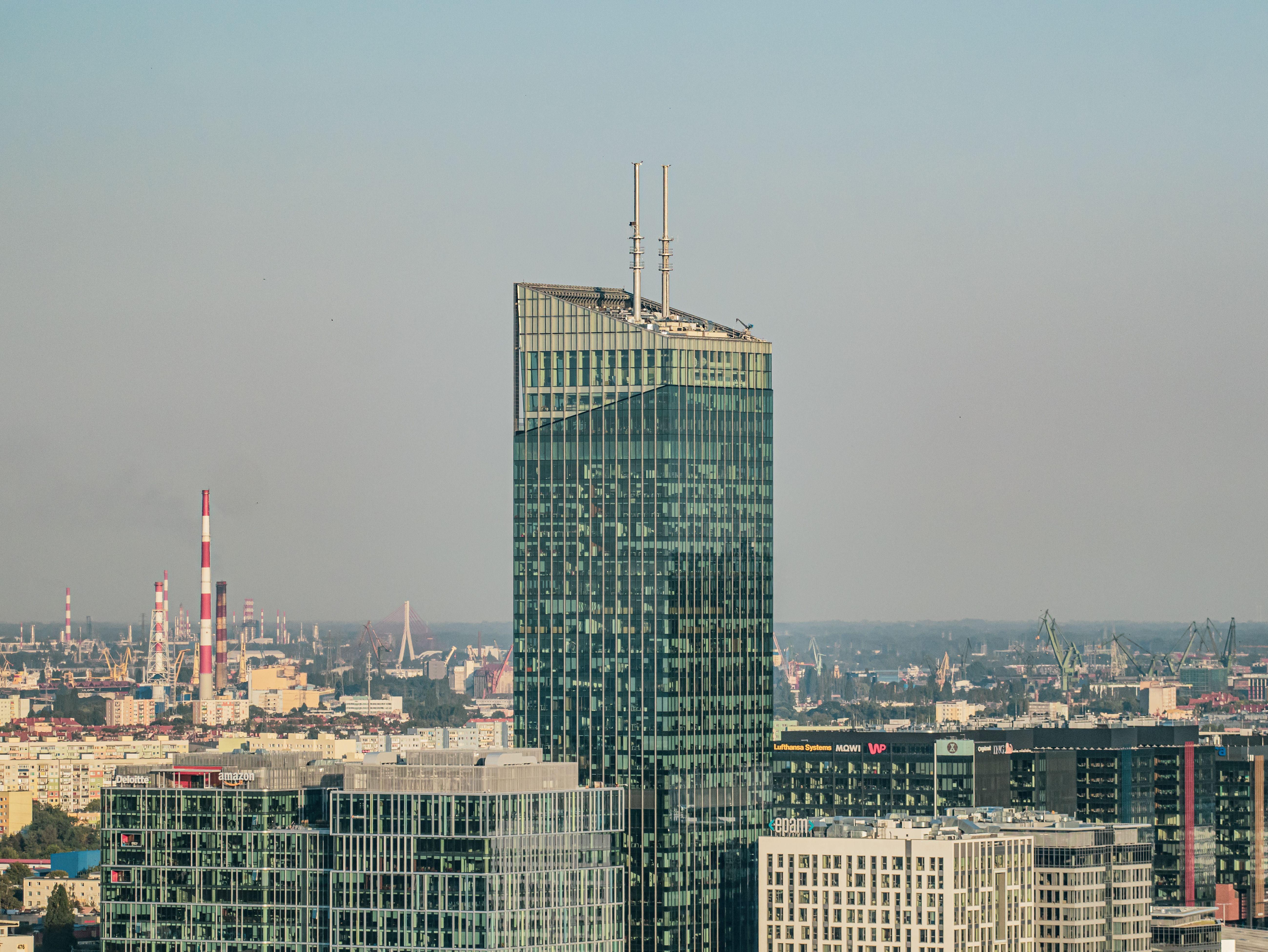 A striking view of a modern skyscraper amidst Gdańsk's cityscape, showcasing urban architecture.