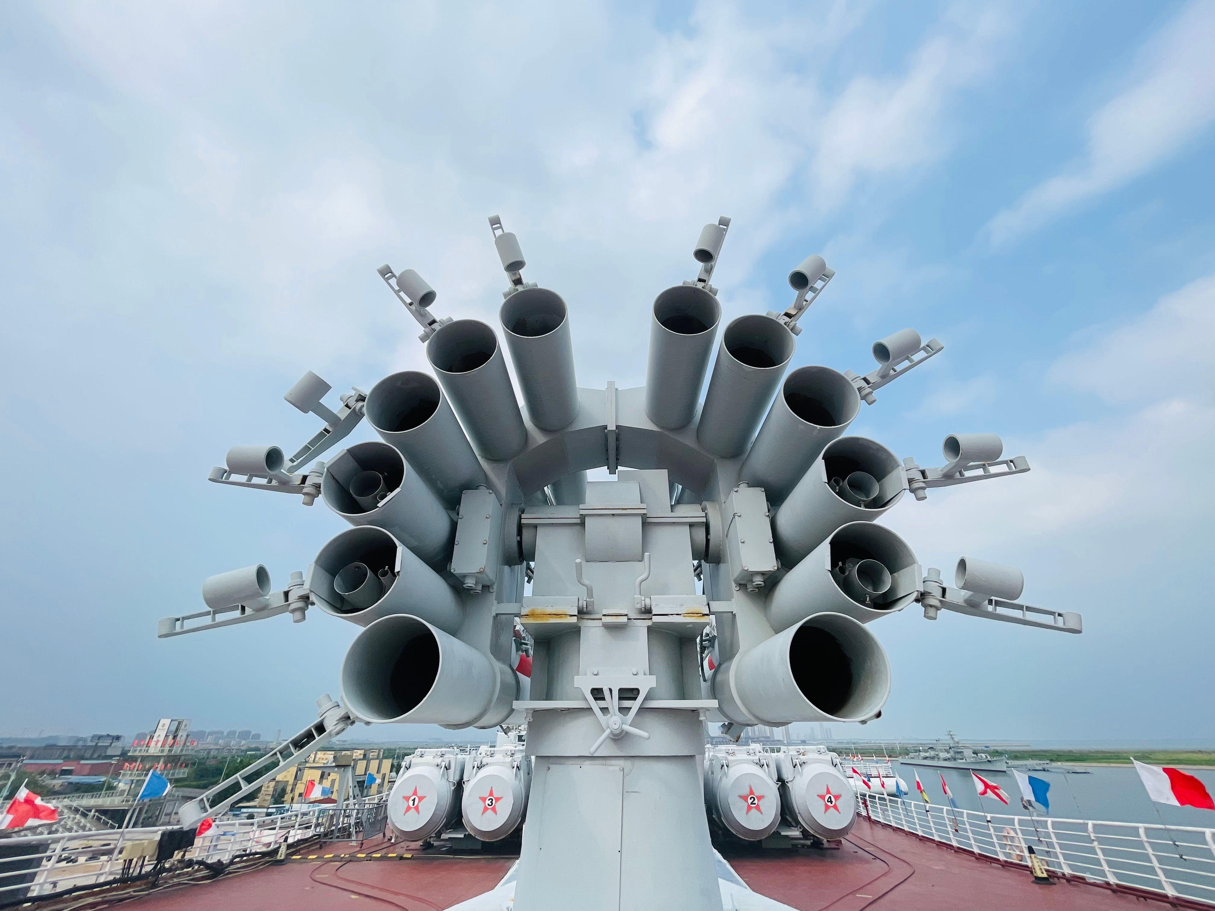 Close-up of naval artillery on a warship at Tianjin Harbour, China, showcasing military might.