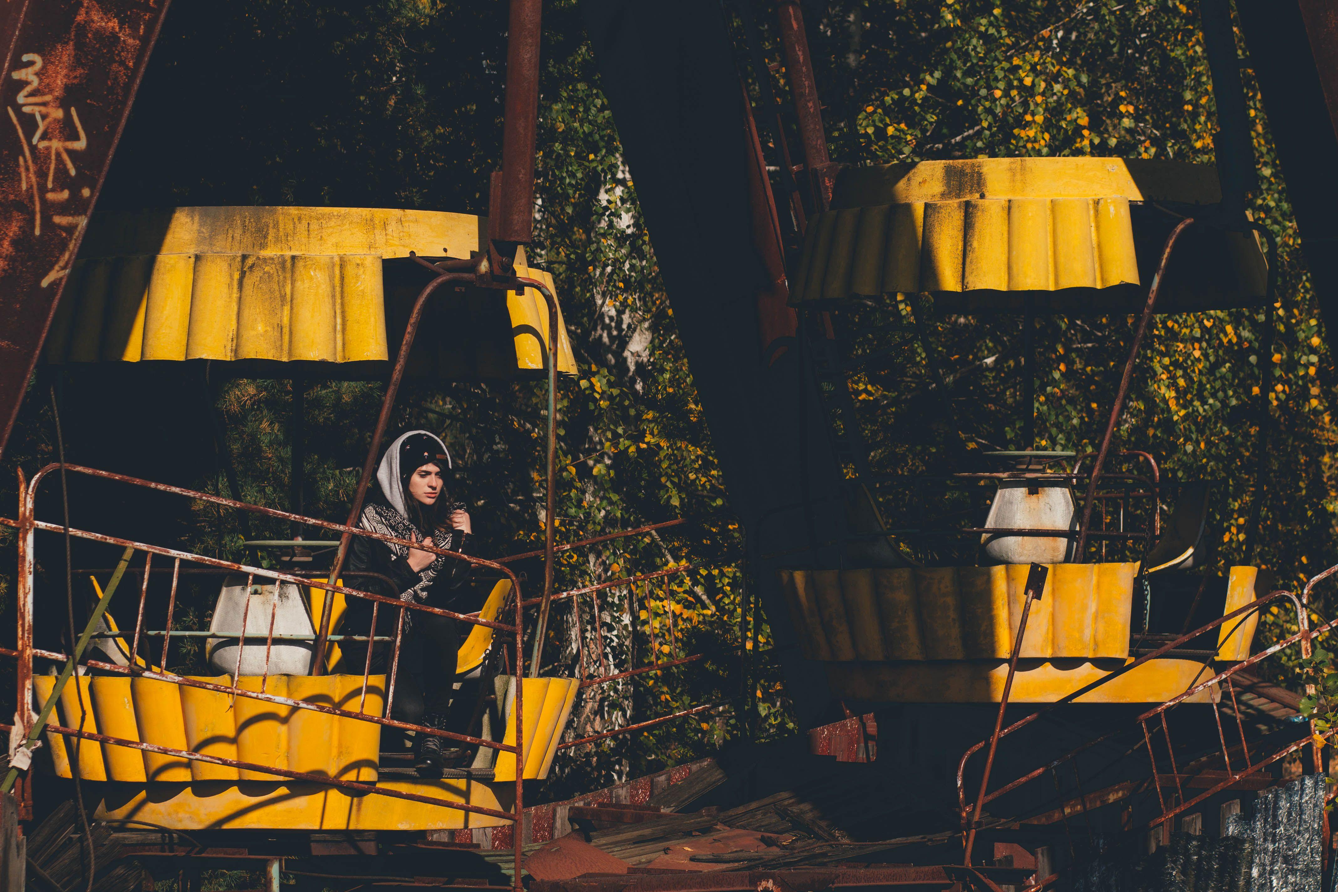Eerie scene of an abandoned ferris wheel in Chernobyl featuring a lone woman.
