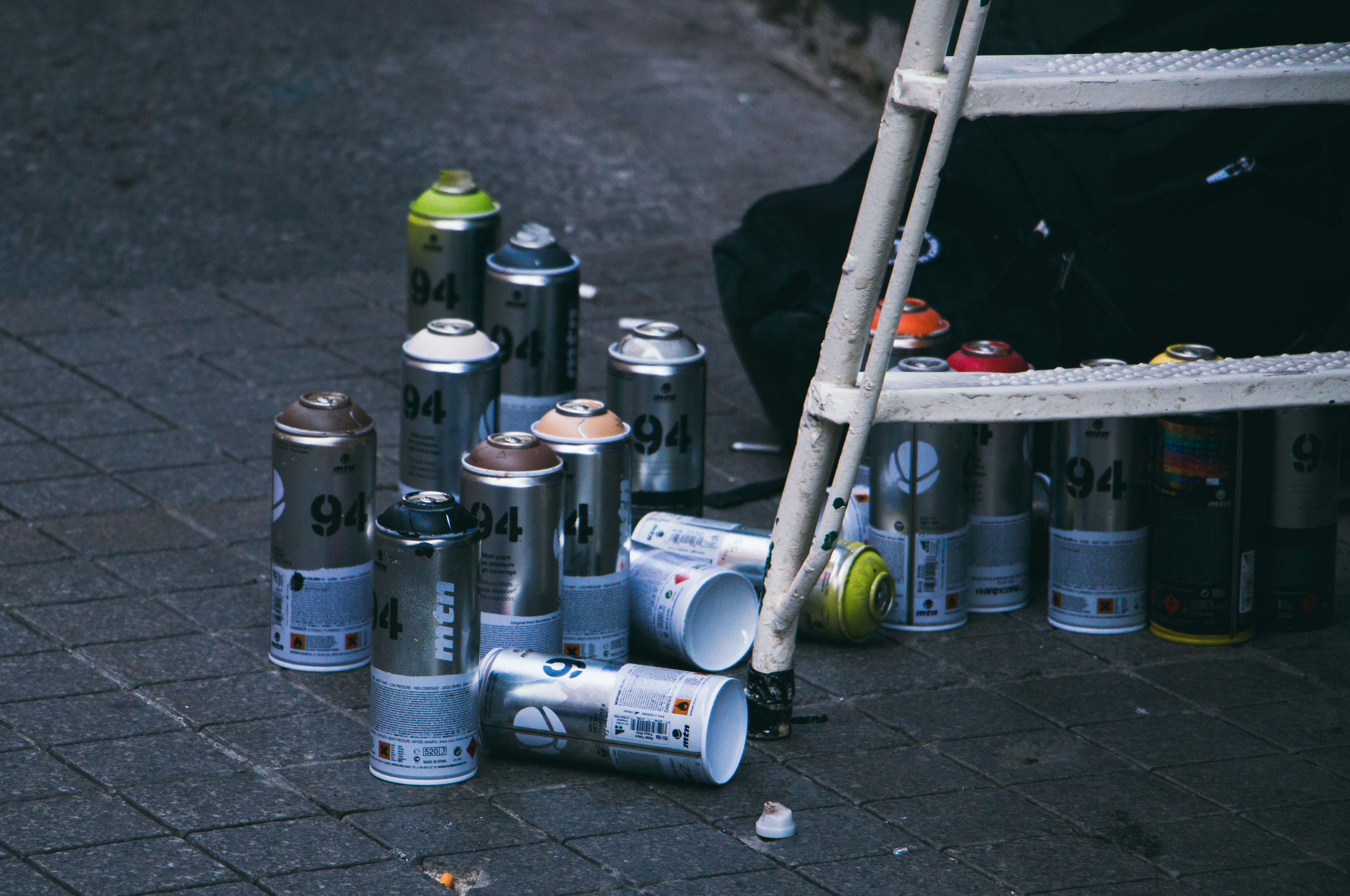 Collection of used spray paint cans and ladder on a street in Istanbul, ideal for urban art themes.
