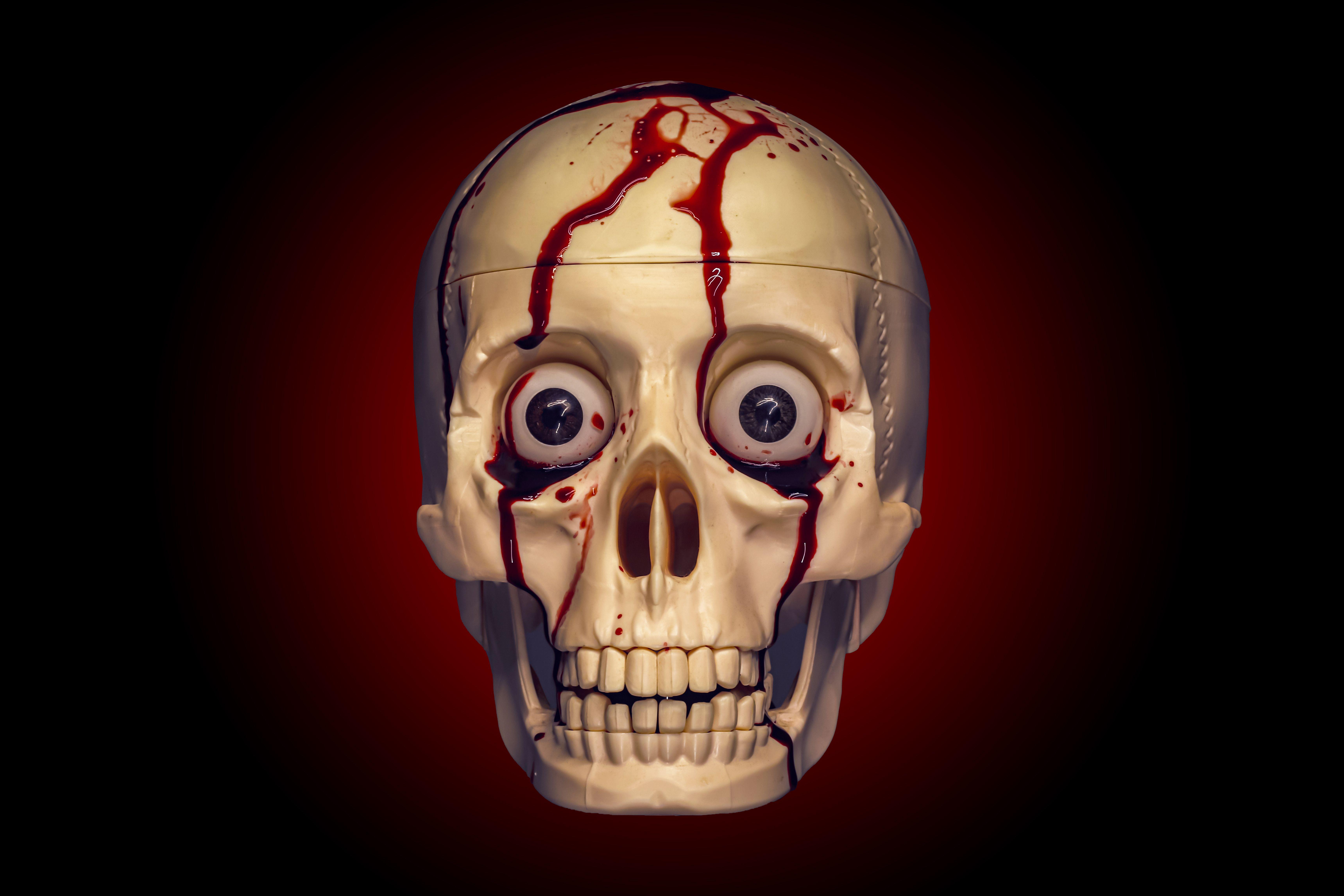 Realistic skull with creepy eyes and blood trickling, perfect for horror themes.