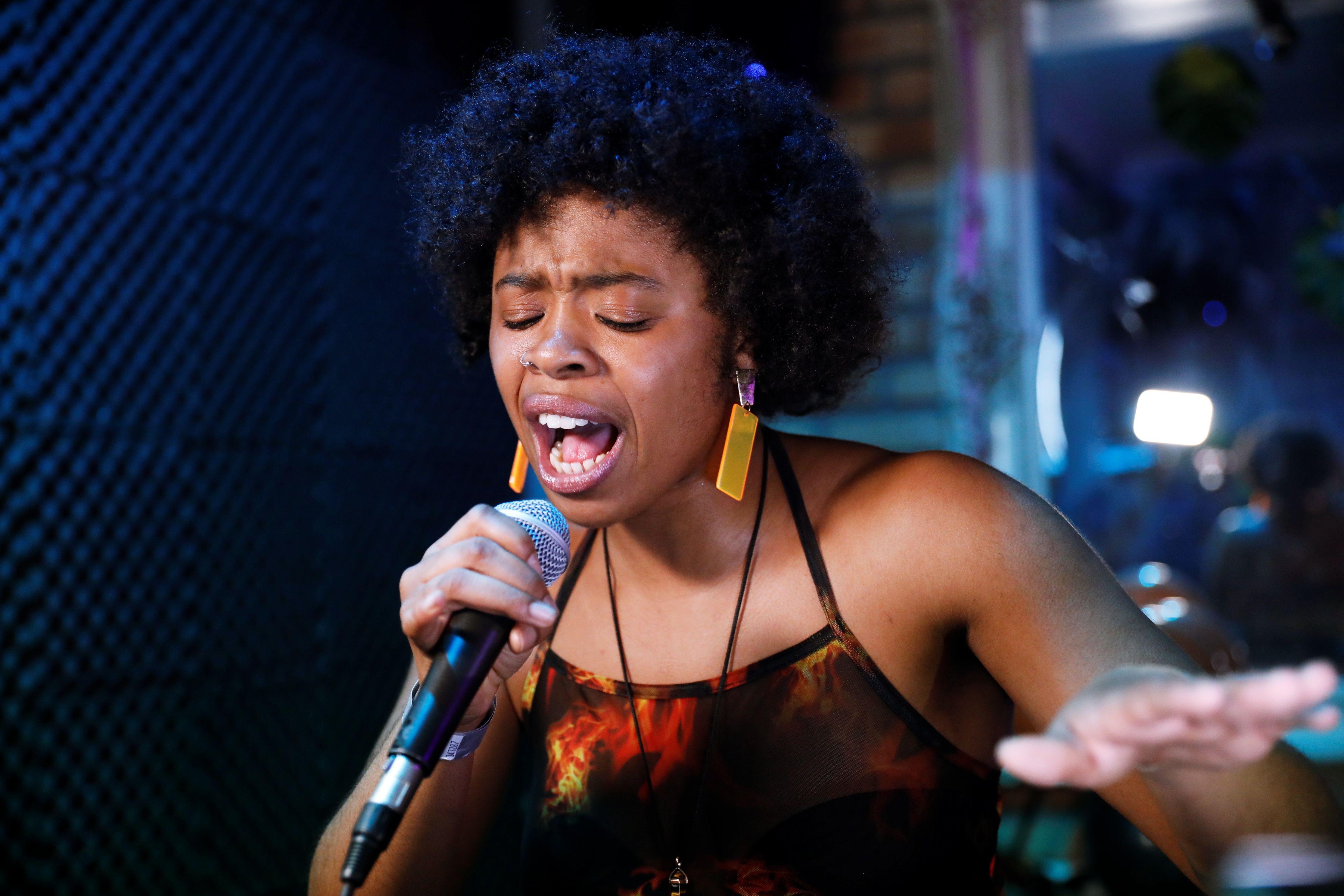 Vibrant performance by a black female singer in a London music venue.