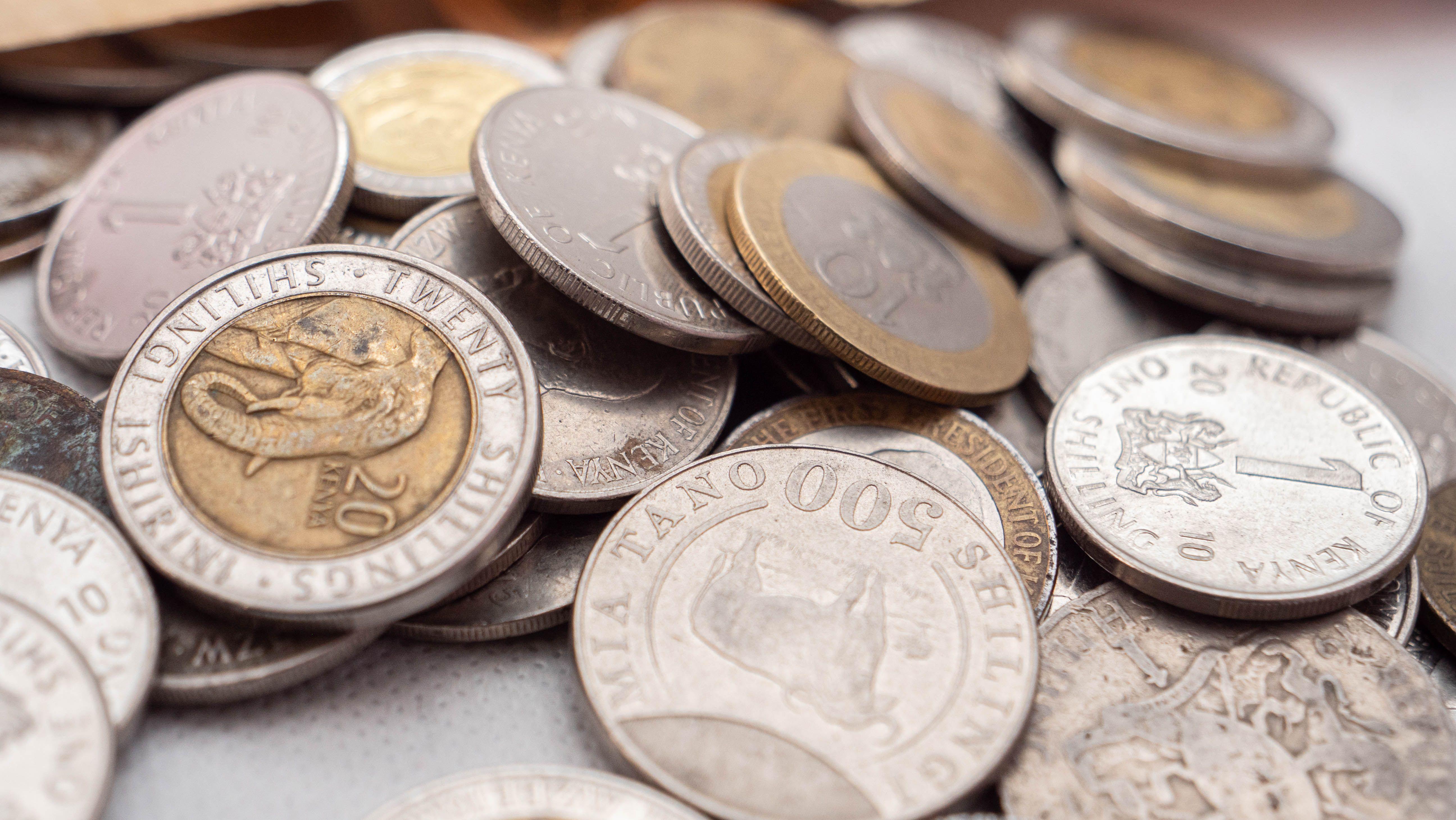 A detailed close-up image showcasing various Kenyan shilling coins, emphasizing their textures and inscriptions.