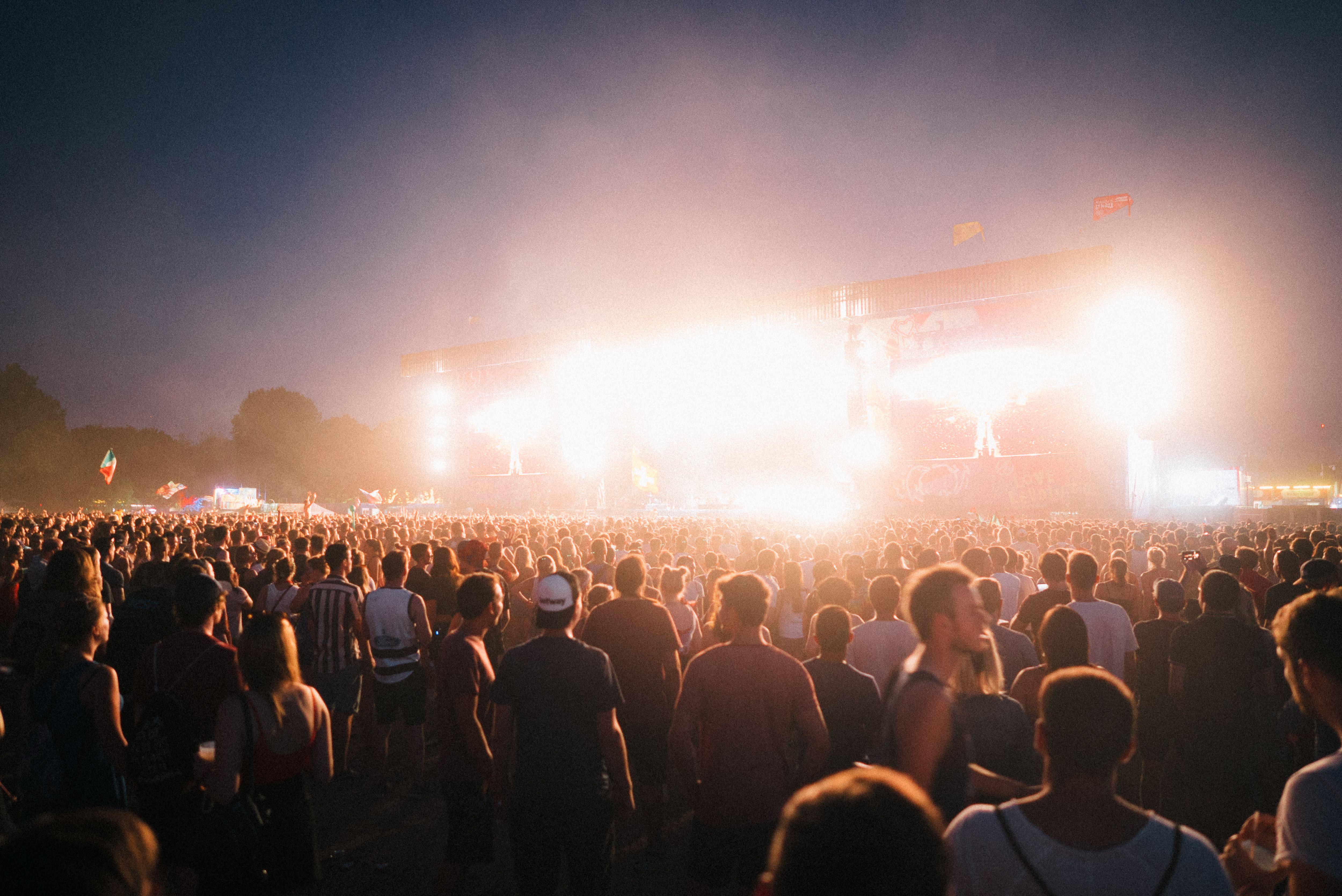 A lively music festival in Budapest with a large crowd enjoying bright stage lights at night.