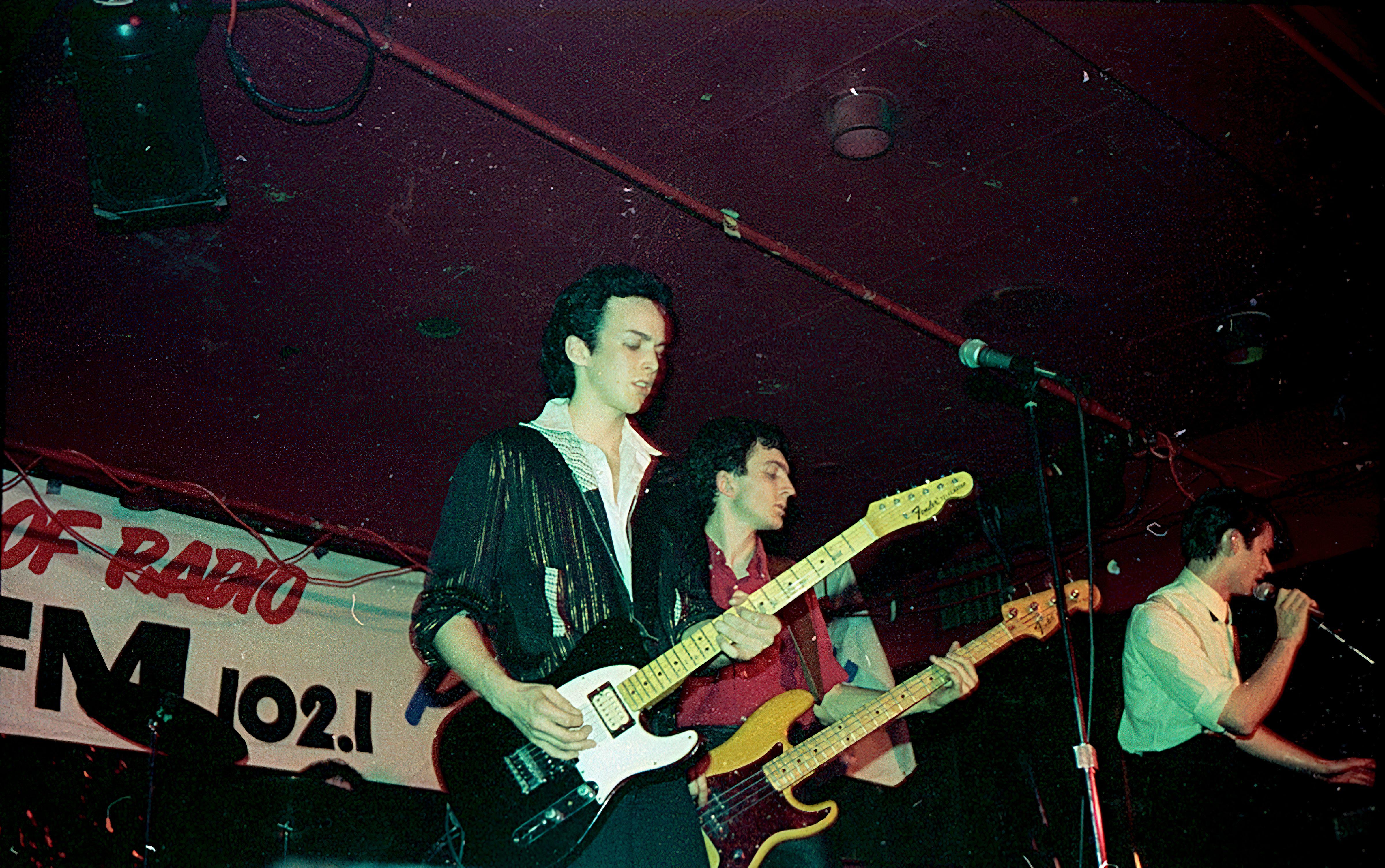 Energetic live performance by musicians playing guitars at an indoor concert.