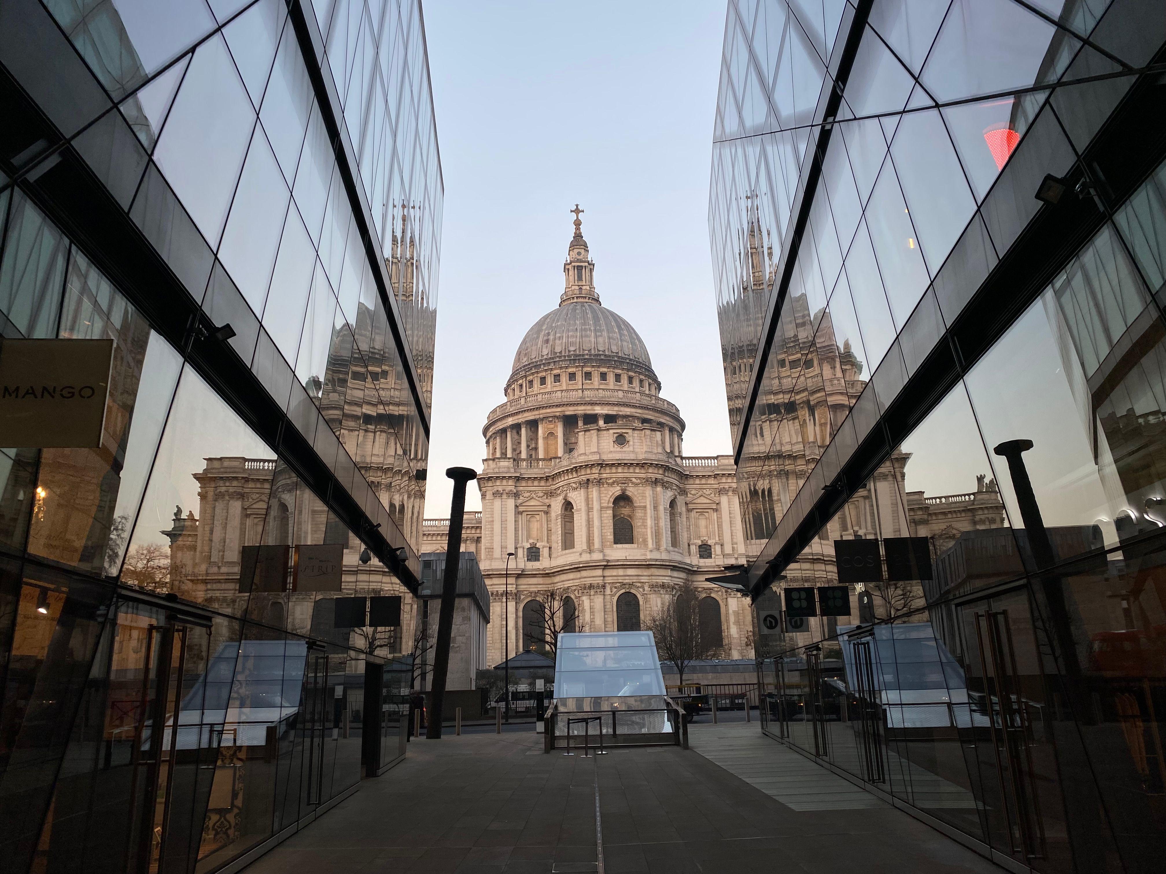 A stunning view of St. Paul's Cathedral framed by modern glass buildings in London.