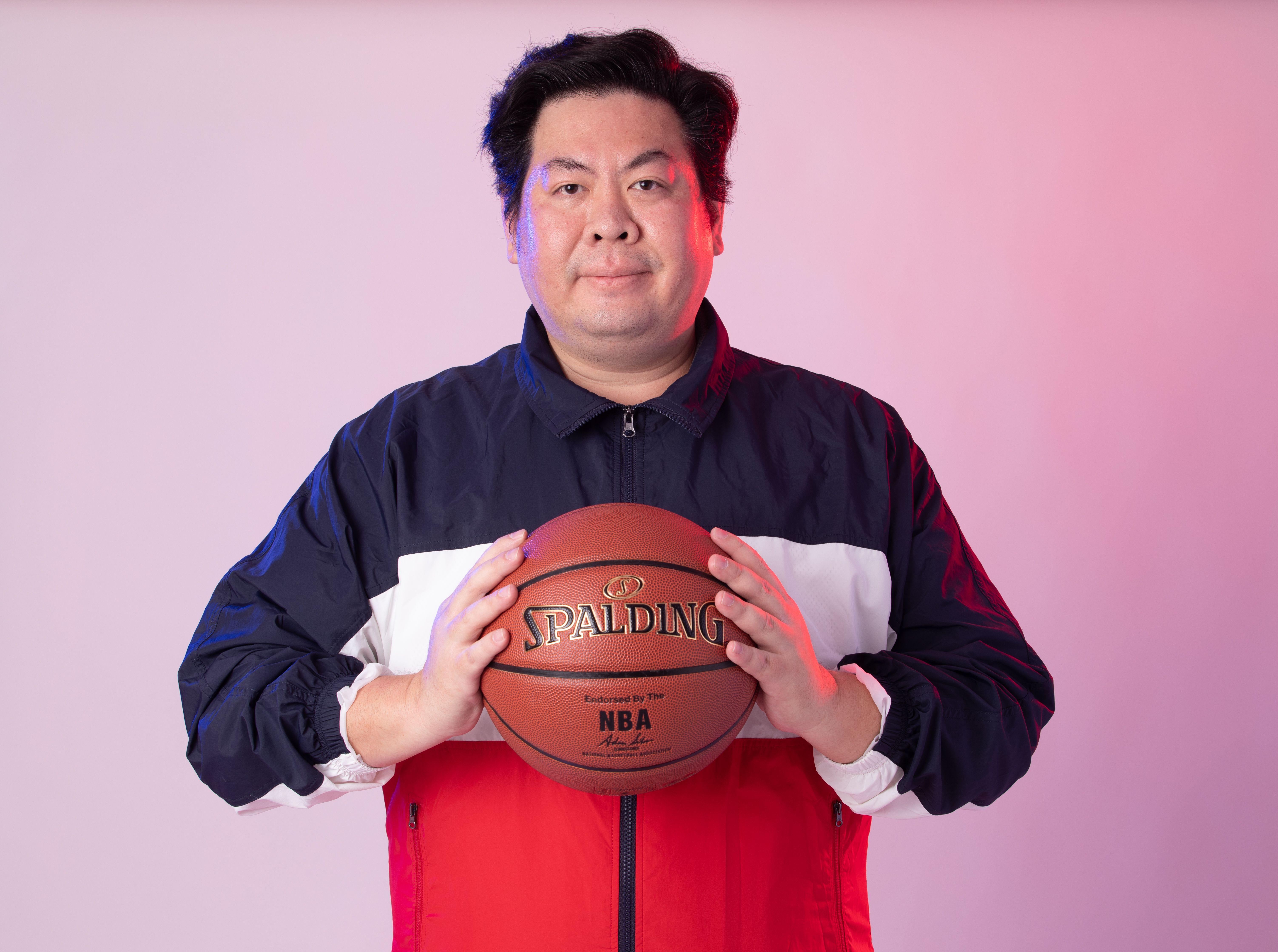 Man in sportswear with basketball against a gradient background.