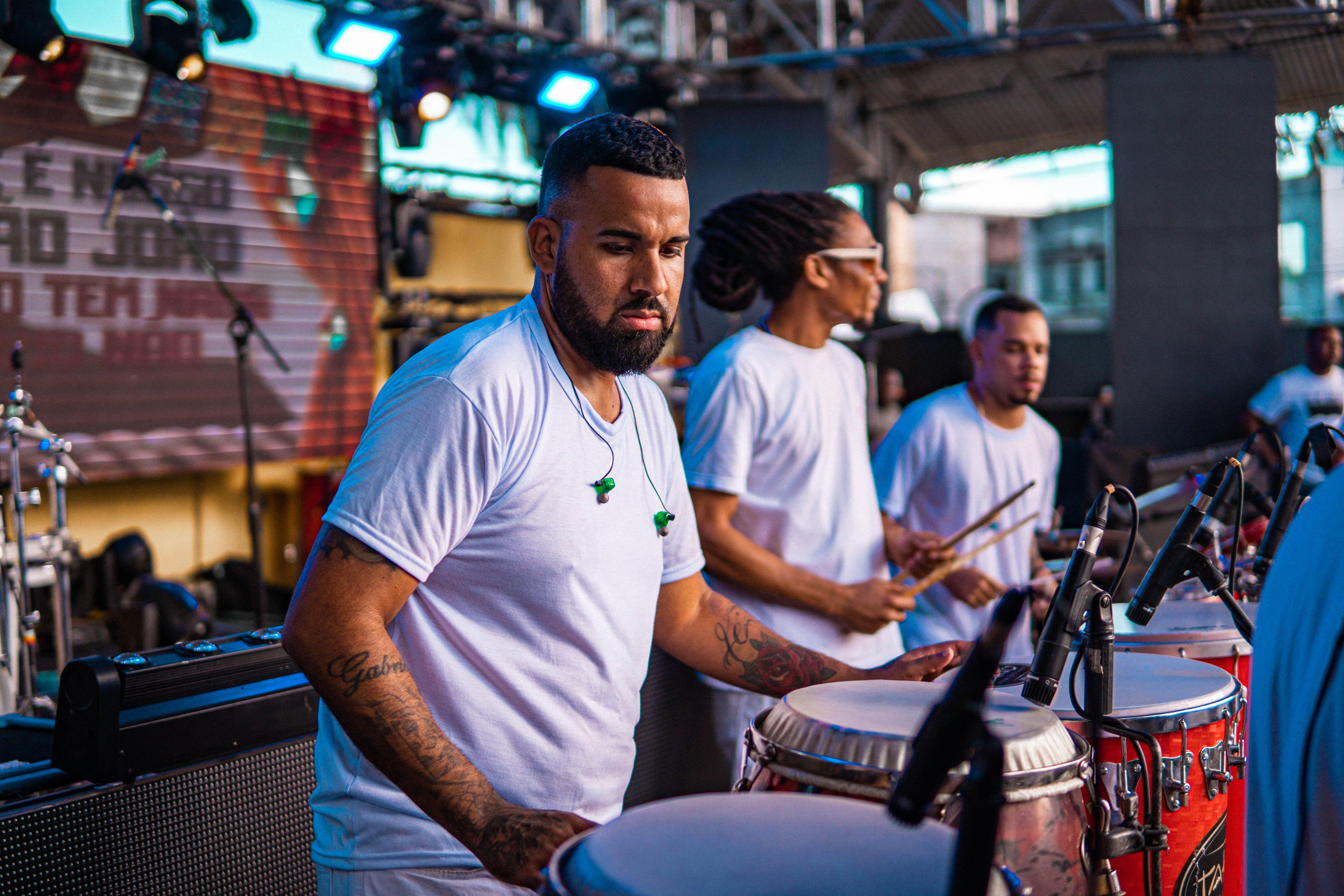 Group of drummers performing live on stage at an outdoor music festival, showcasing musical talent and teamwork.