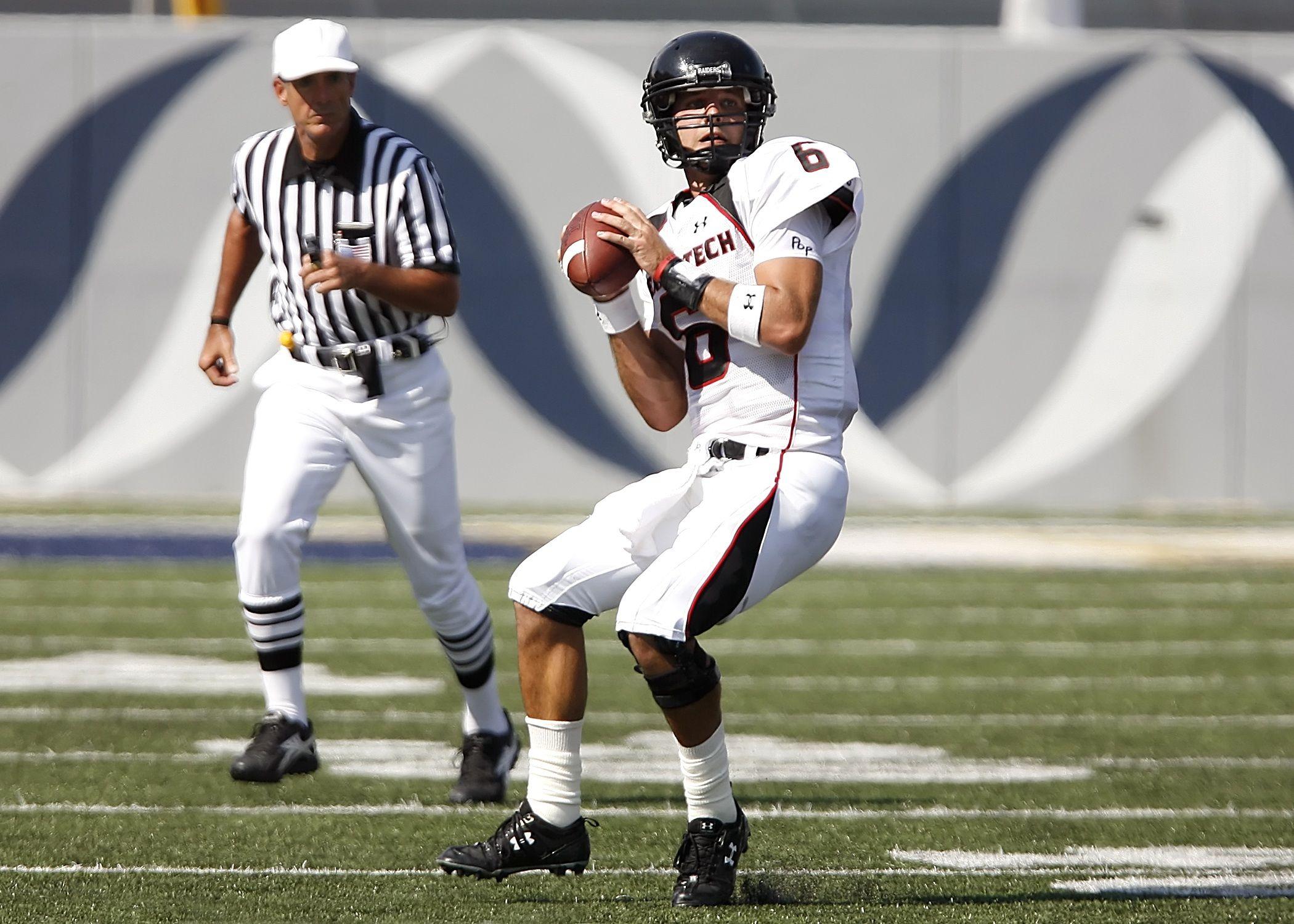 Athlete in uniform preparing to throw during an outdoor football game.