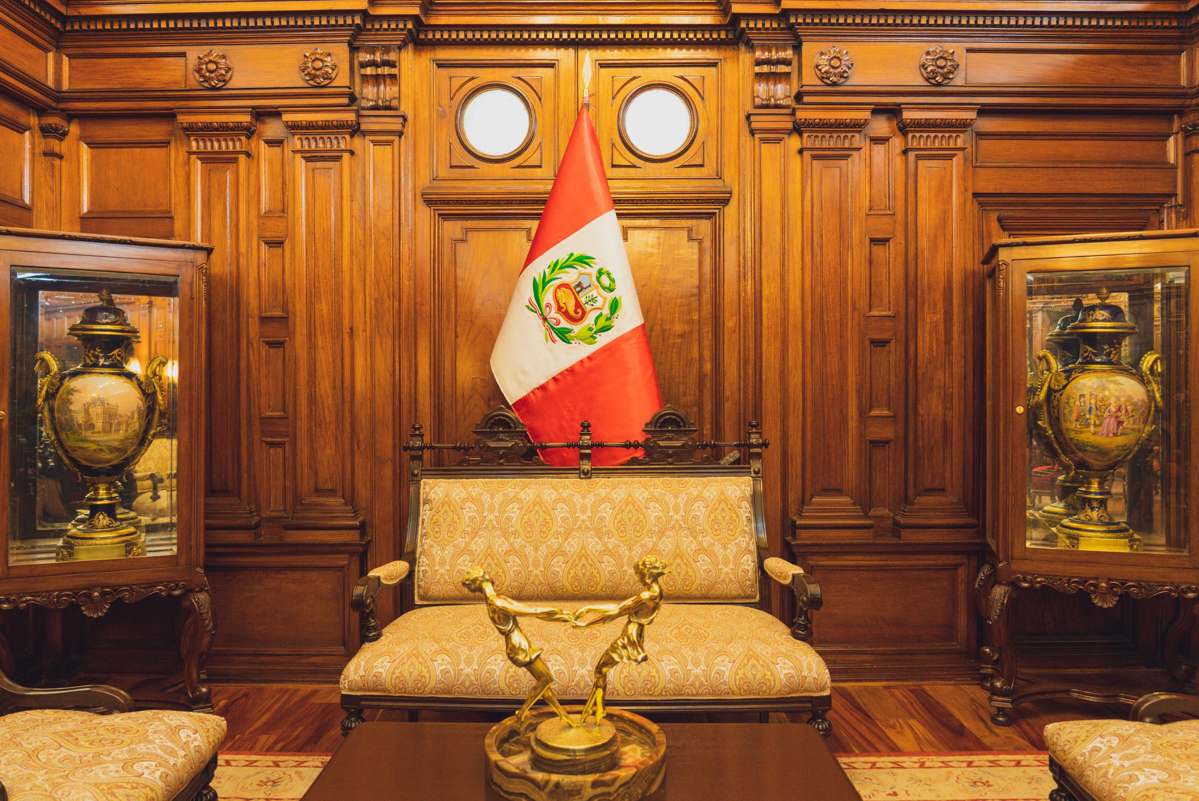 Stylish interior in Lima featuring ornate furniture and the Peruvian flag.