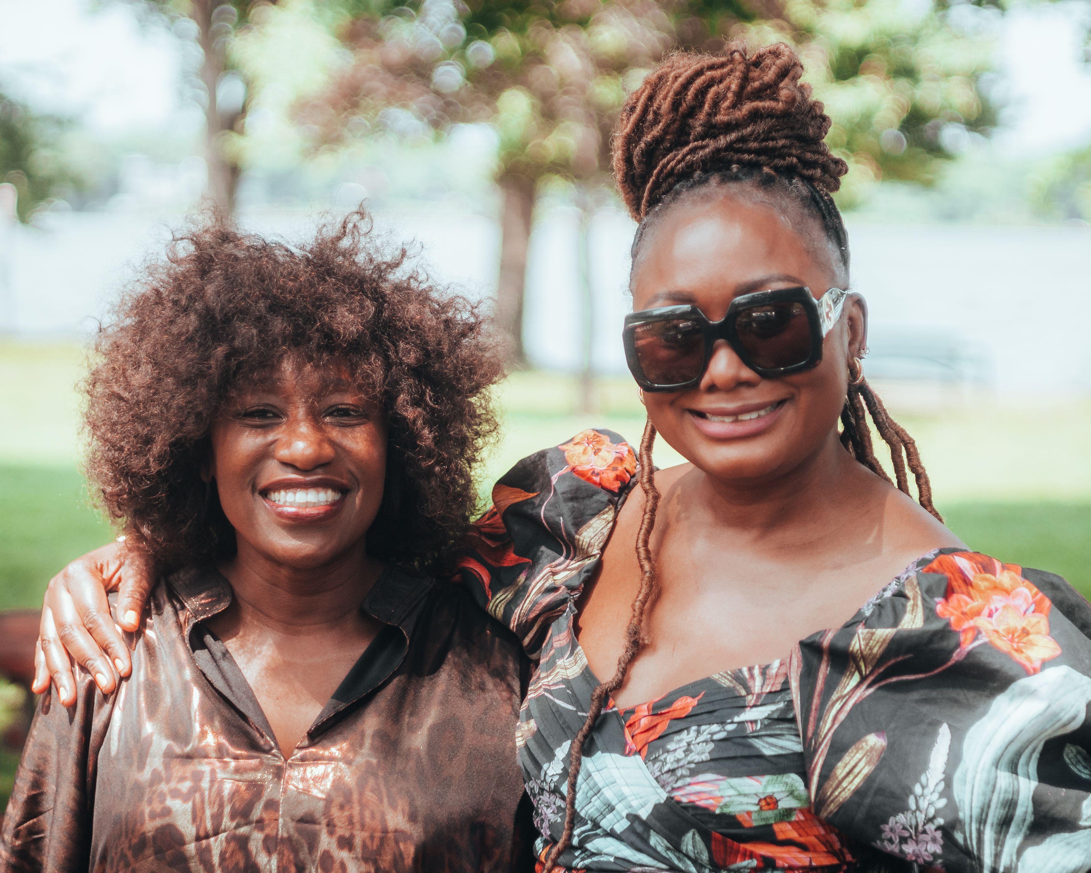 Smiling friends in colorful attire enjoying a sunny day in the park.