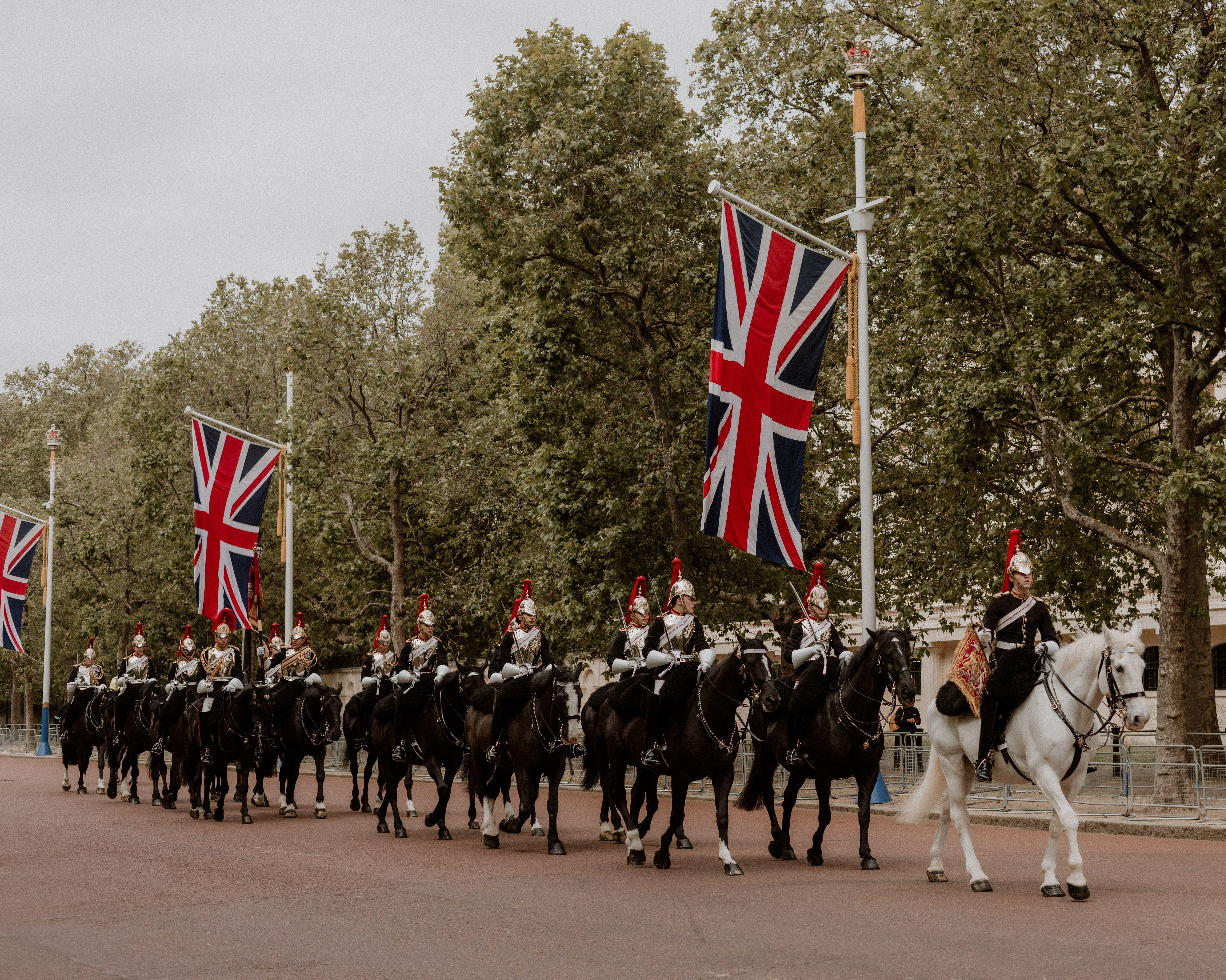 Ceremonial cavalry with Union Flags in a historical parade on The Mall, London.