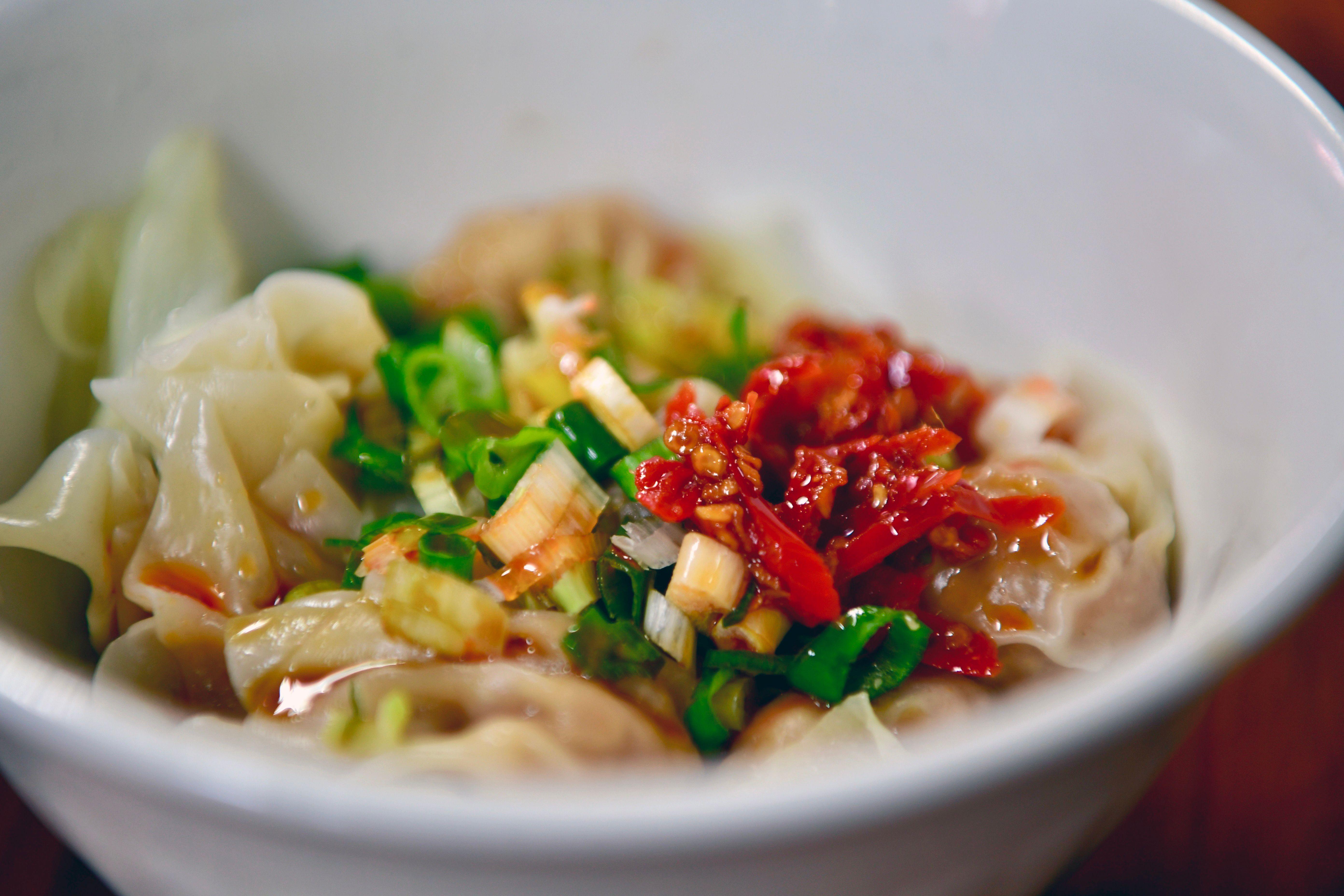 Delicious Taiwanese dumplings garnished with fresh chili and scallions, capturing authentic Asian flavors.