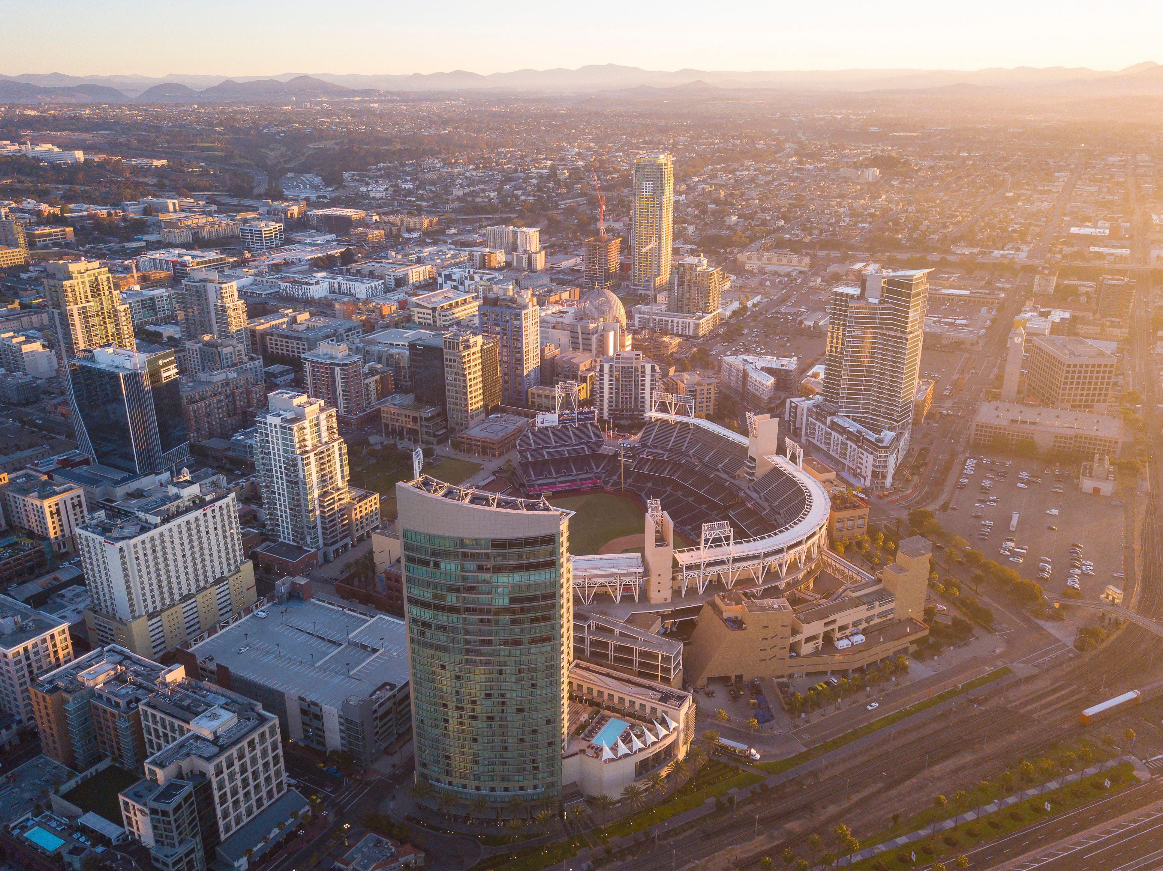Aerial view of downtown San Diego featuring Petco Park and surrounding cityscape at sunset.