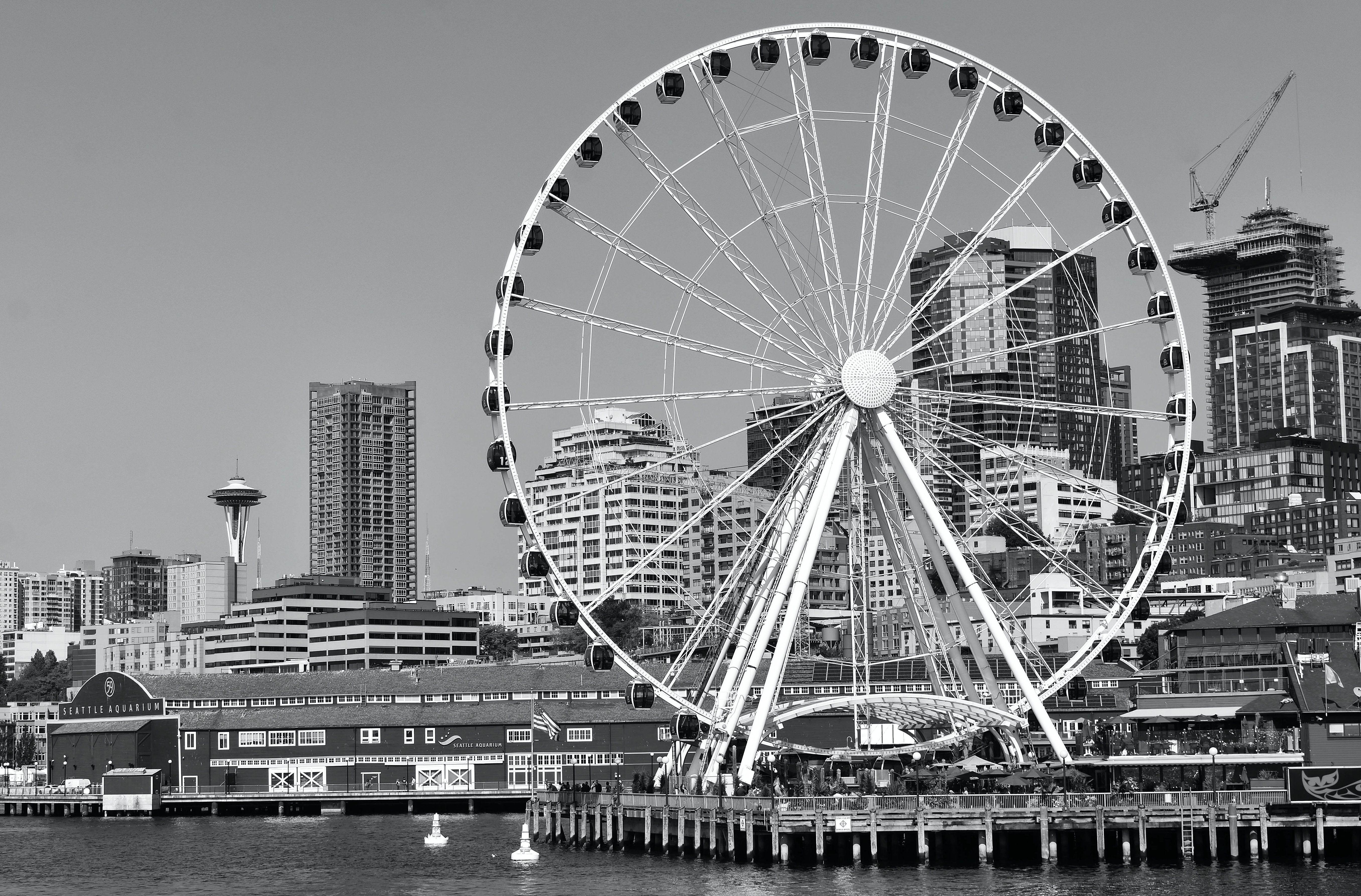 Black and white view of Seattle's Great Wheel and city skyline featuring iconic landmarks.