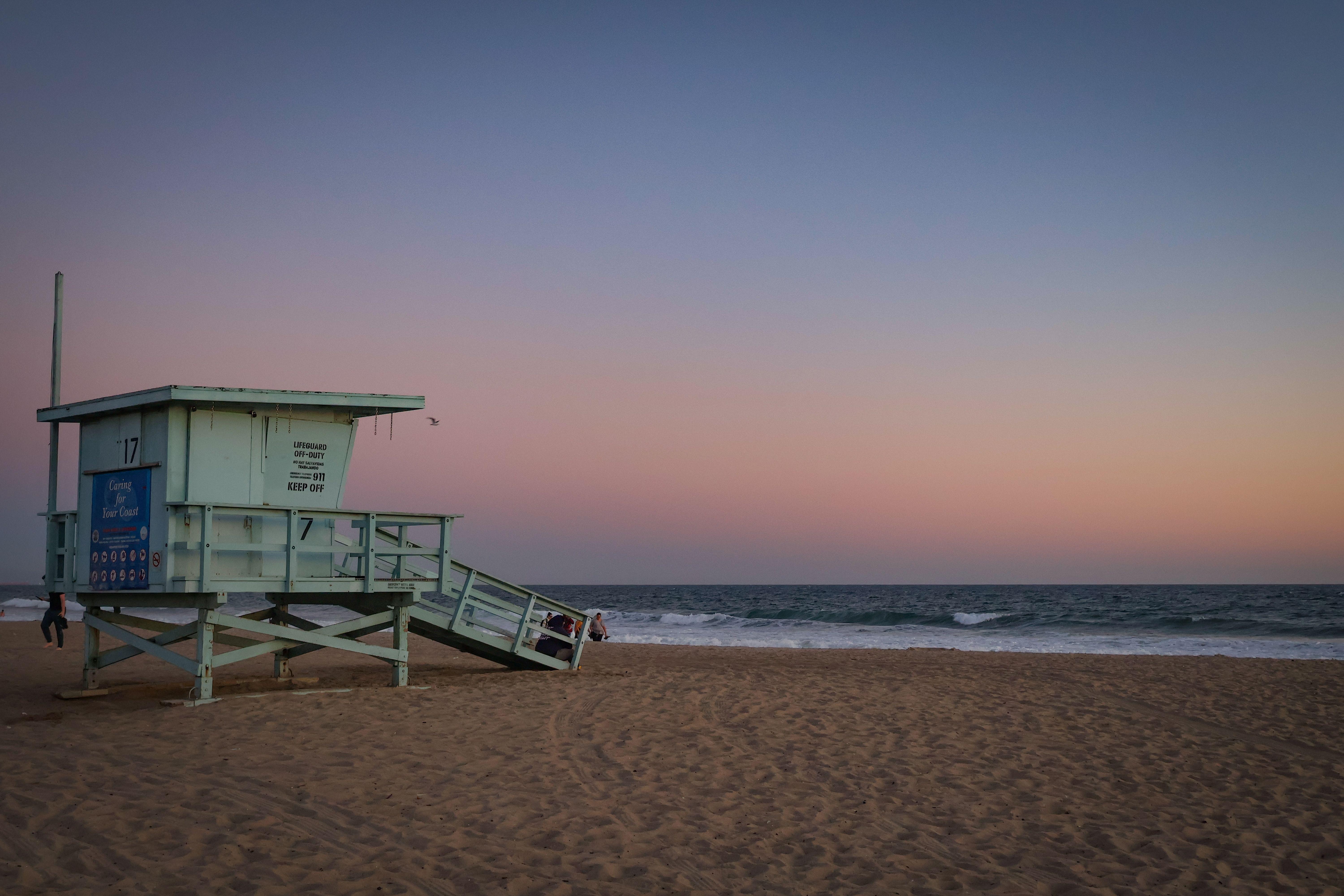 Beautiful dusk scene at Santa Monica Beach with a lifeguard tower and pastel sky, capturing the essence of a summer evening.