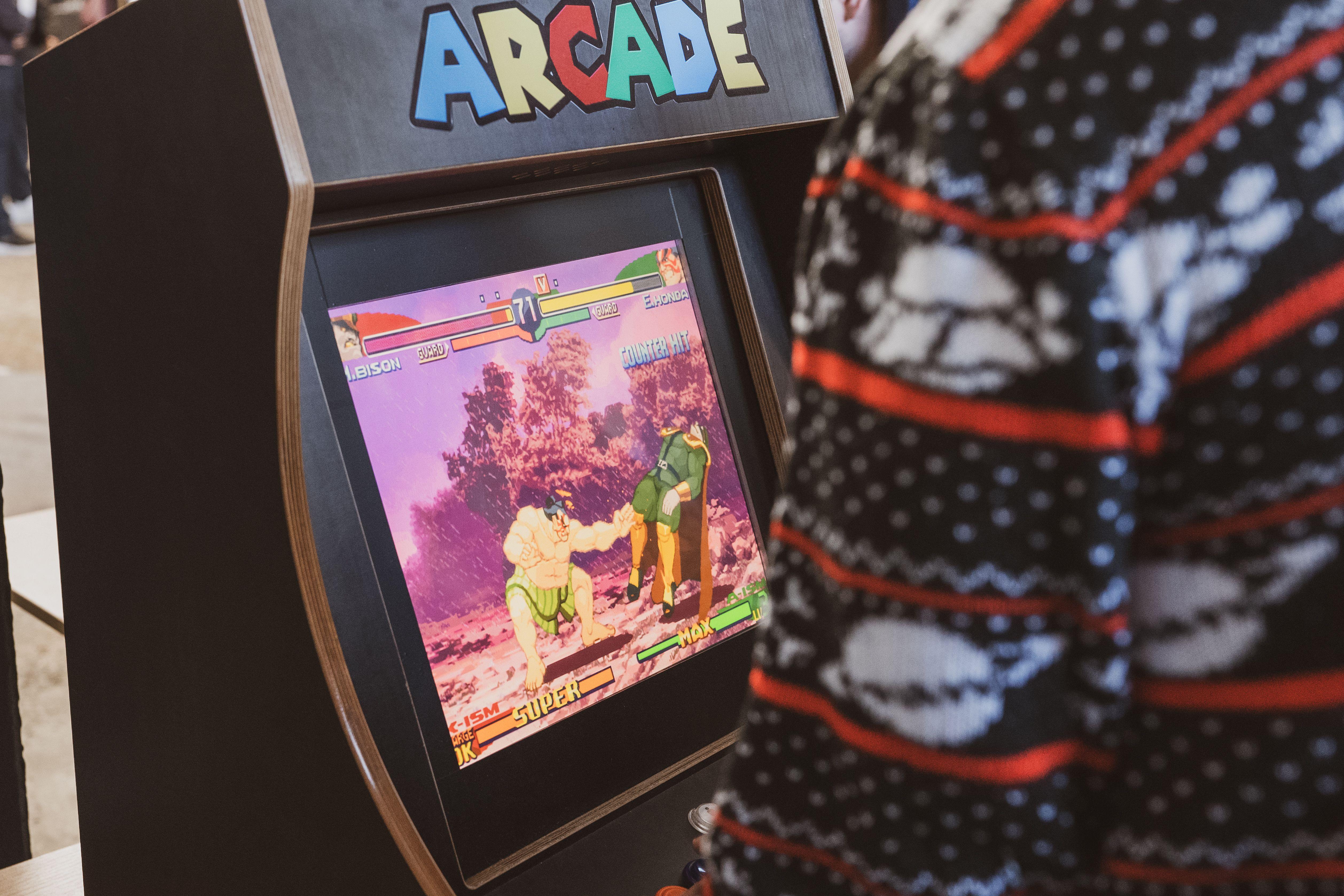 A person in a sweater enjoying a classic arcade game in Zagreb, Hrvatska.