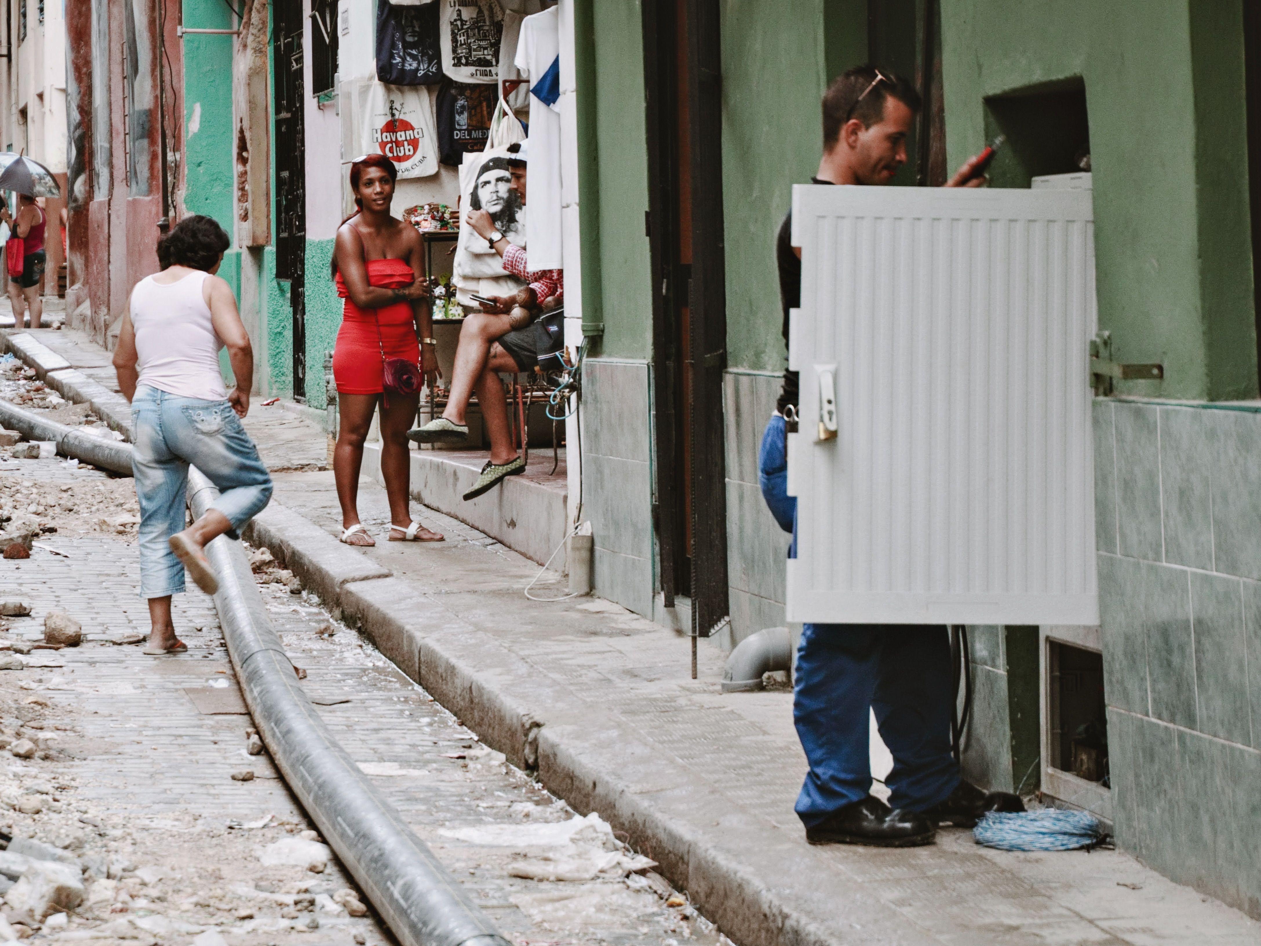 A lively street scene in Havana showcasing diverse people and ongoing street repairs.