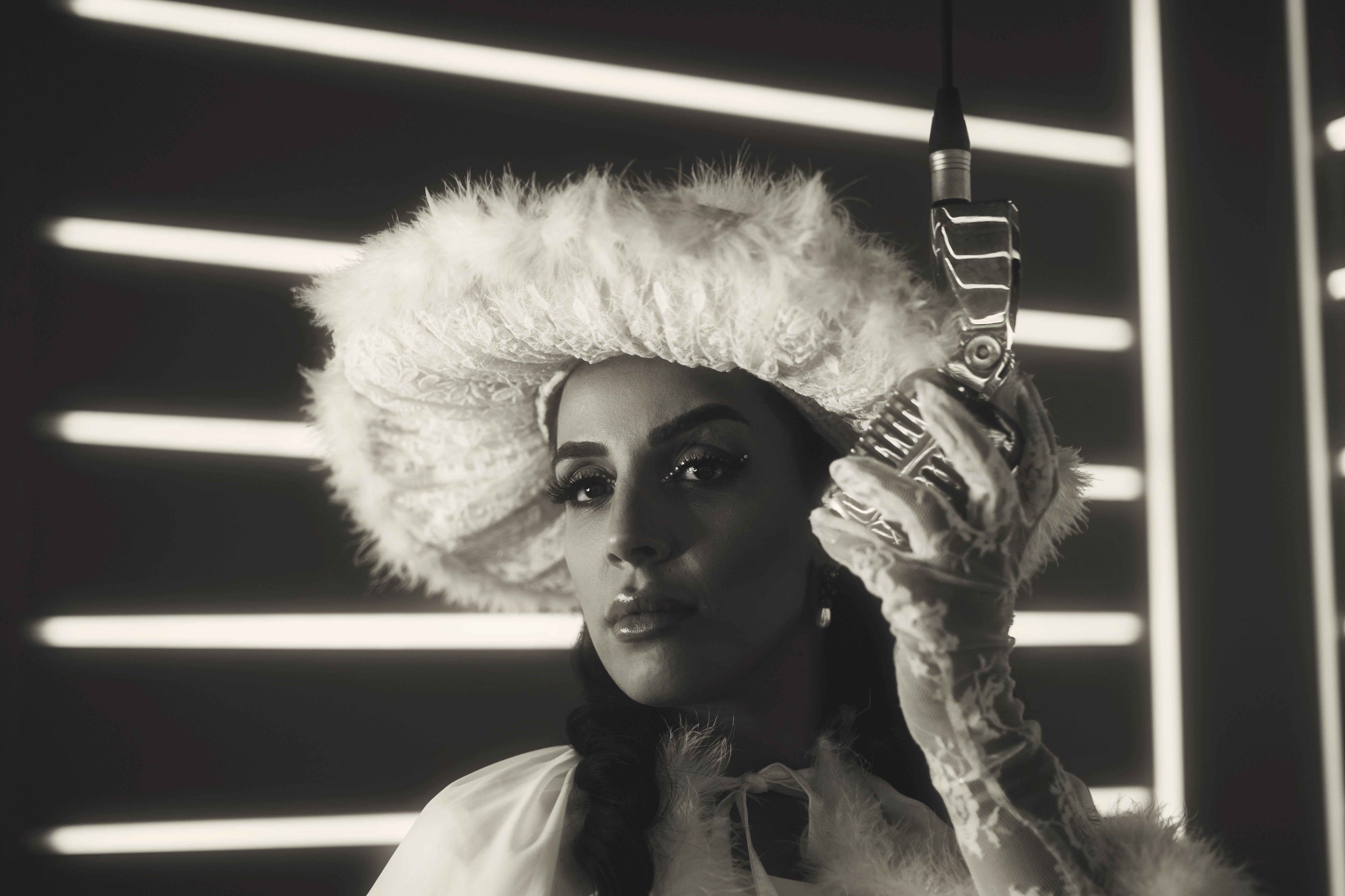 Elegant woman in vintage attire with fur hat and lace gloves holding a microphone.