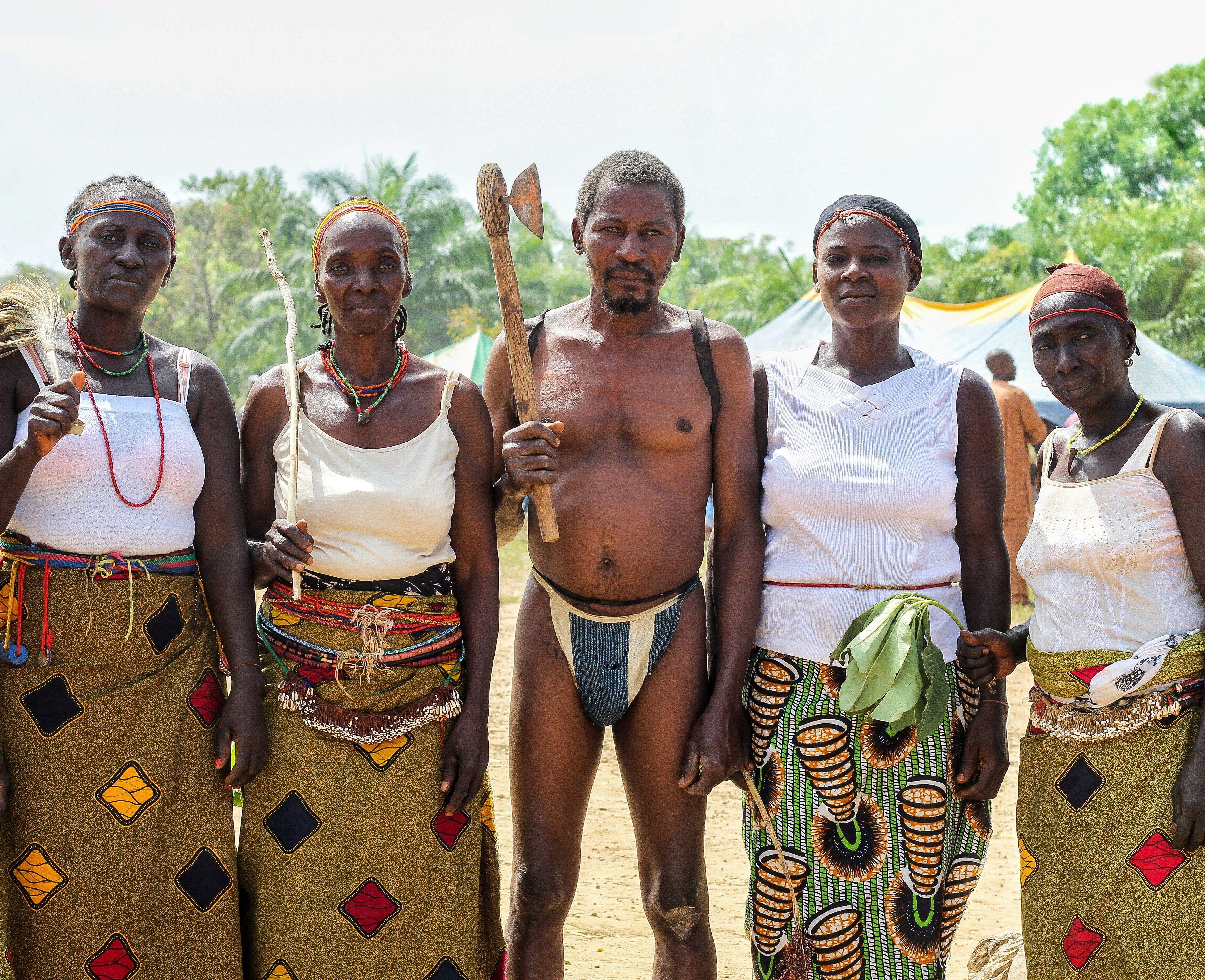 A group of African adults in traditional tribal clothing posing outdoors, showcasing cultural heritage.