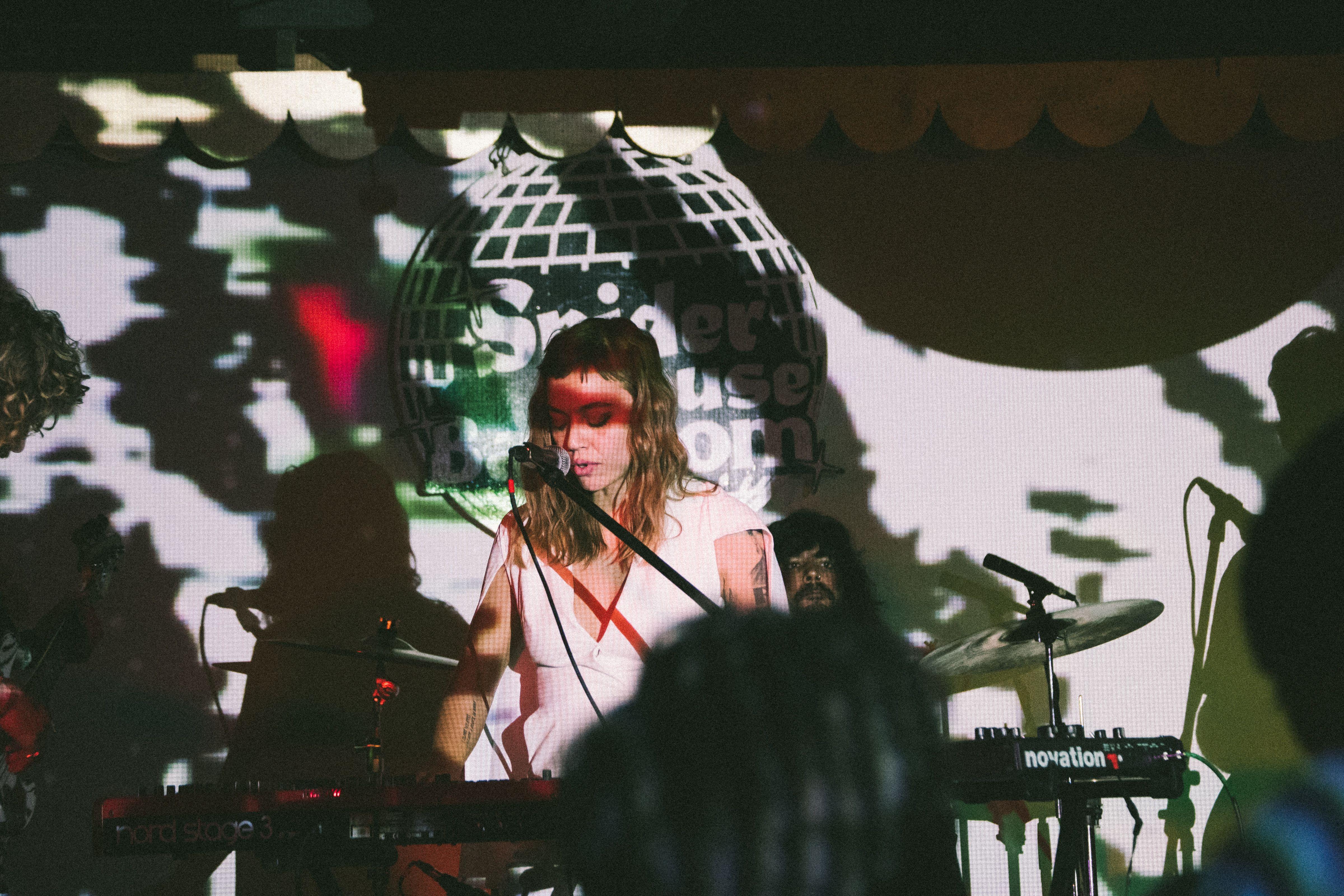A captivating live music performance featuring a female musician with dramatic shadow effects on stage.