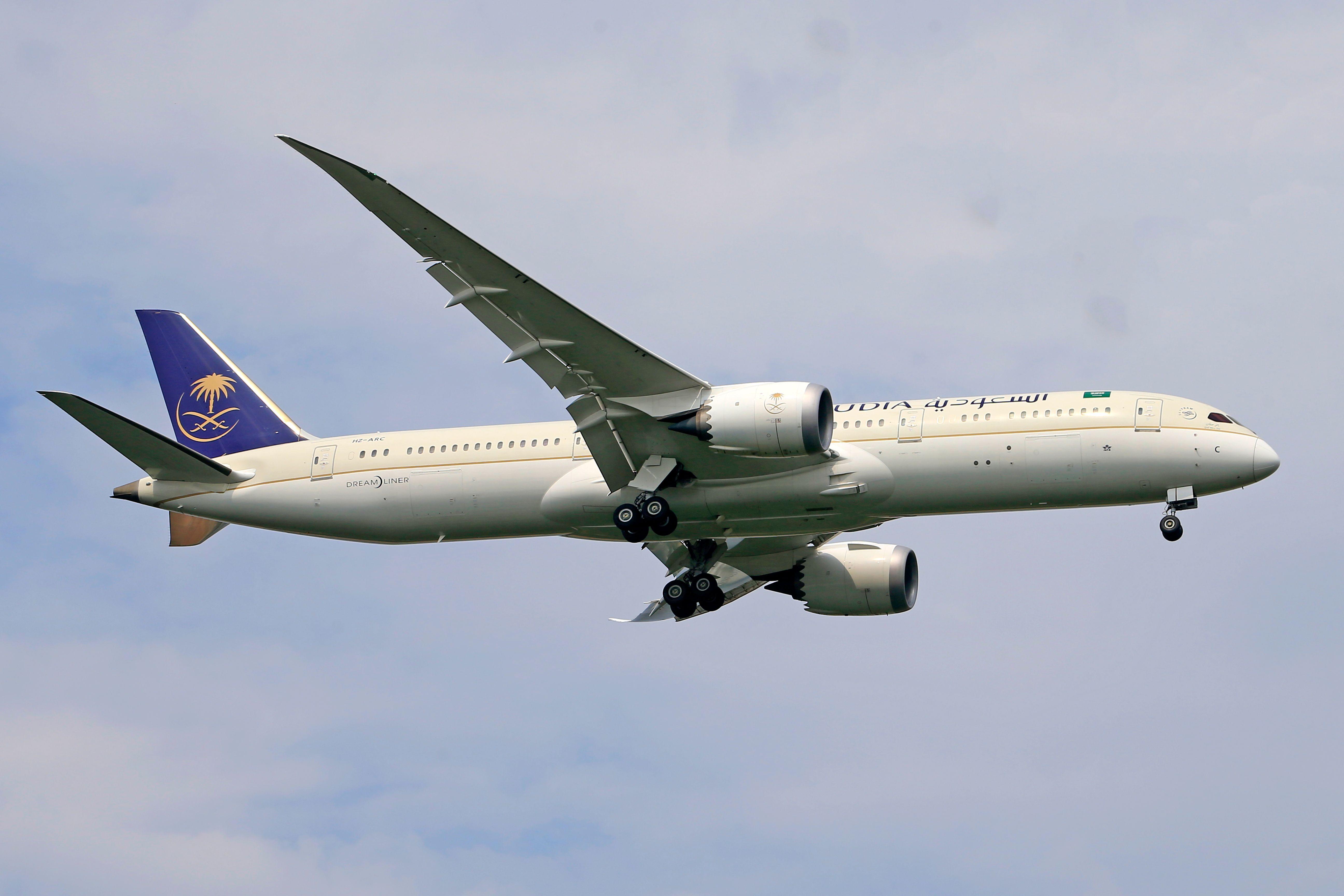 Saudia Airlines Boeing 787 aircraft captured during flight with clear sky background.