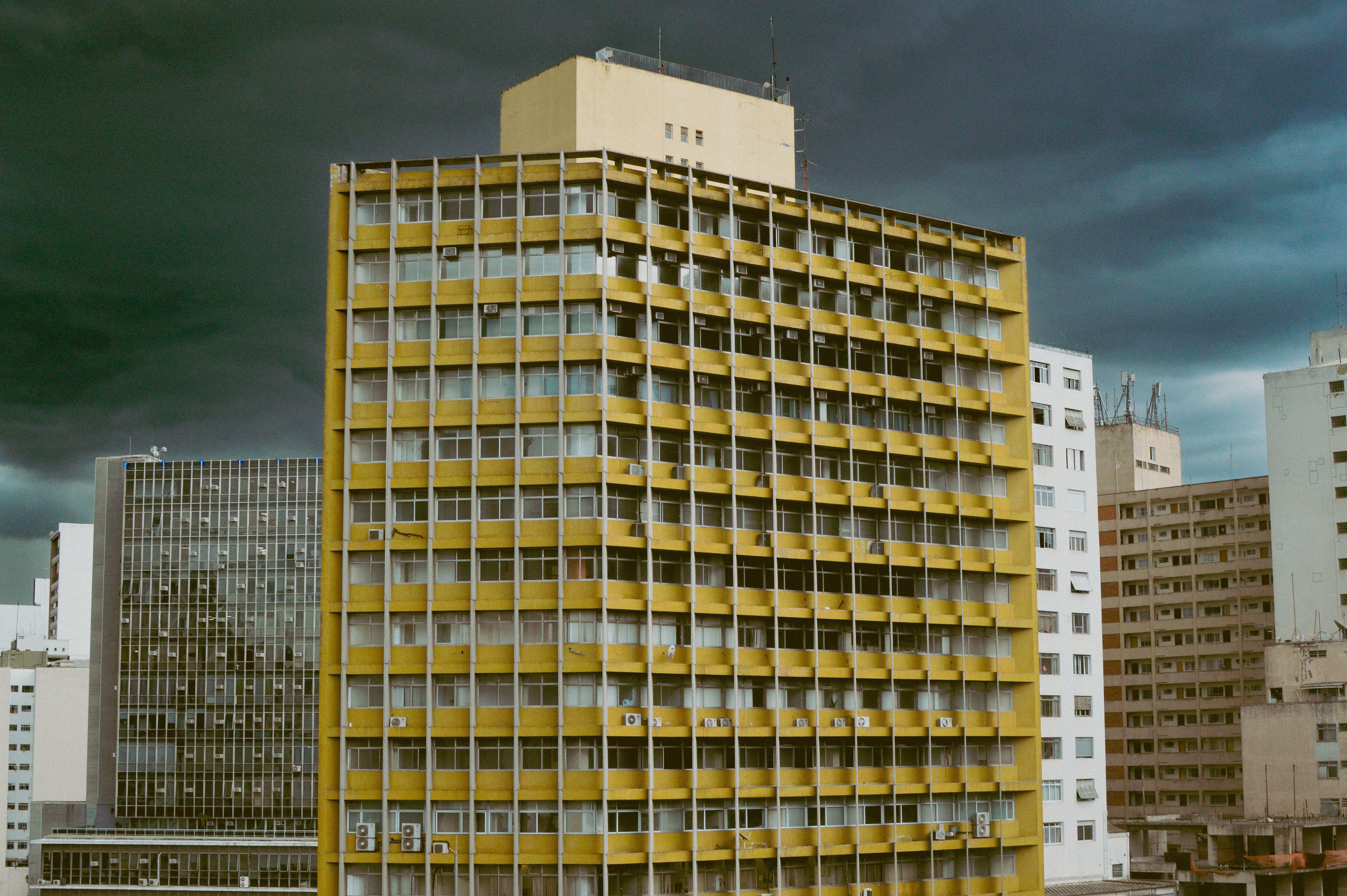 A dramatic view of yellow and brown apartment buildings in Sao Paulo, Brazil's cityscape.