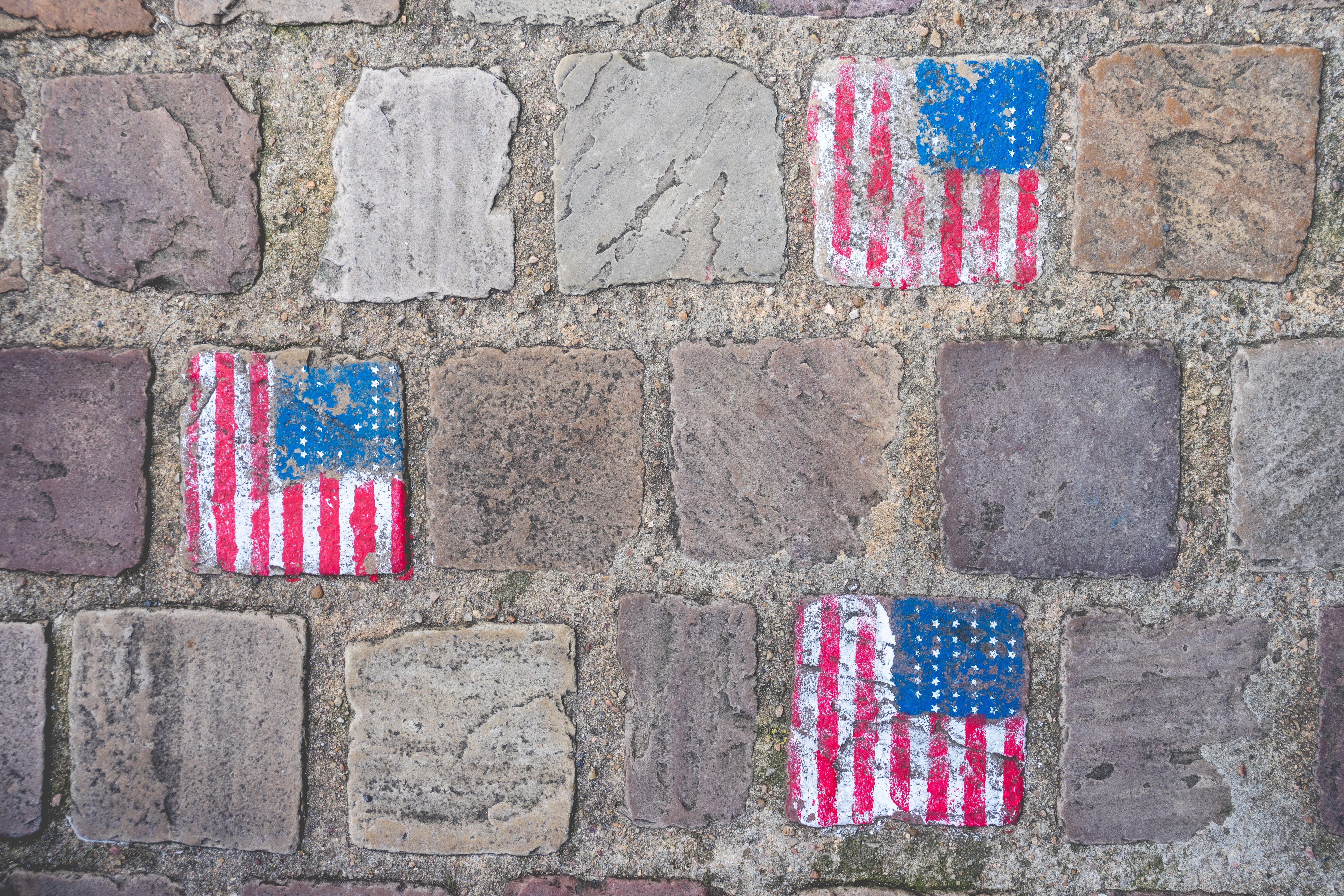 American flag graffiti on old stone wall in Carentan les Marais, Normandy, France.