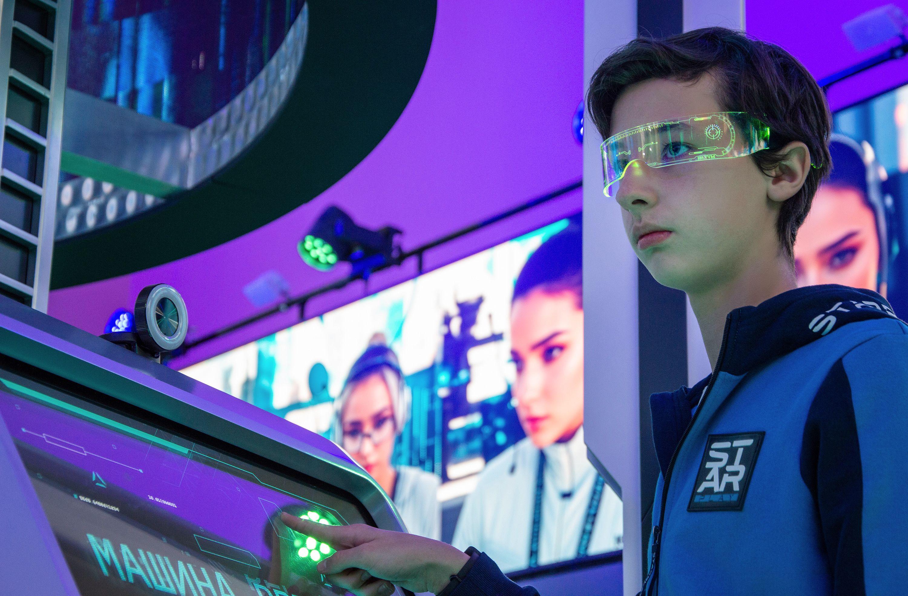 Teenager interacts with advanced touchscreen in a vibrant technology exhibition.
