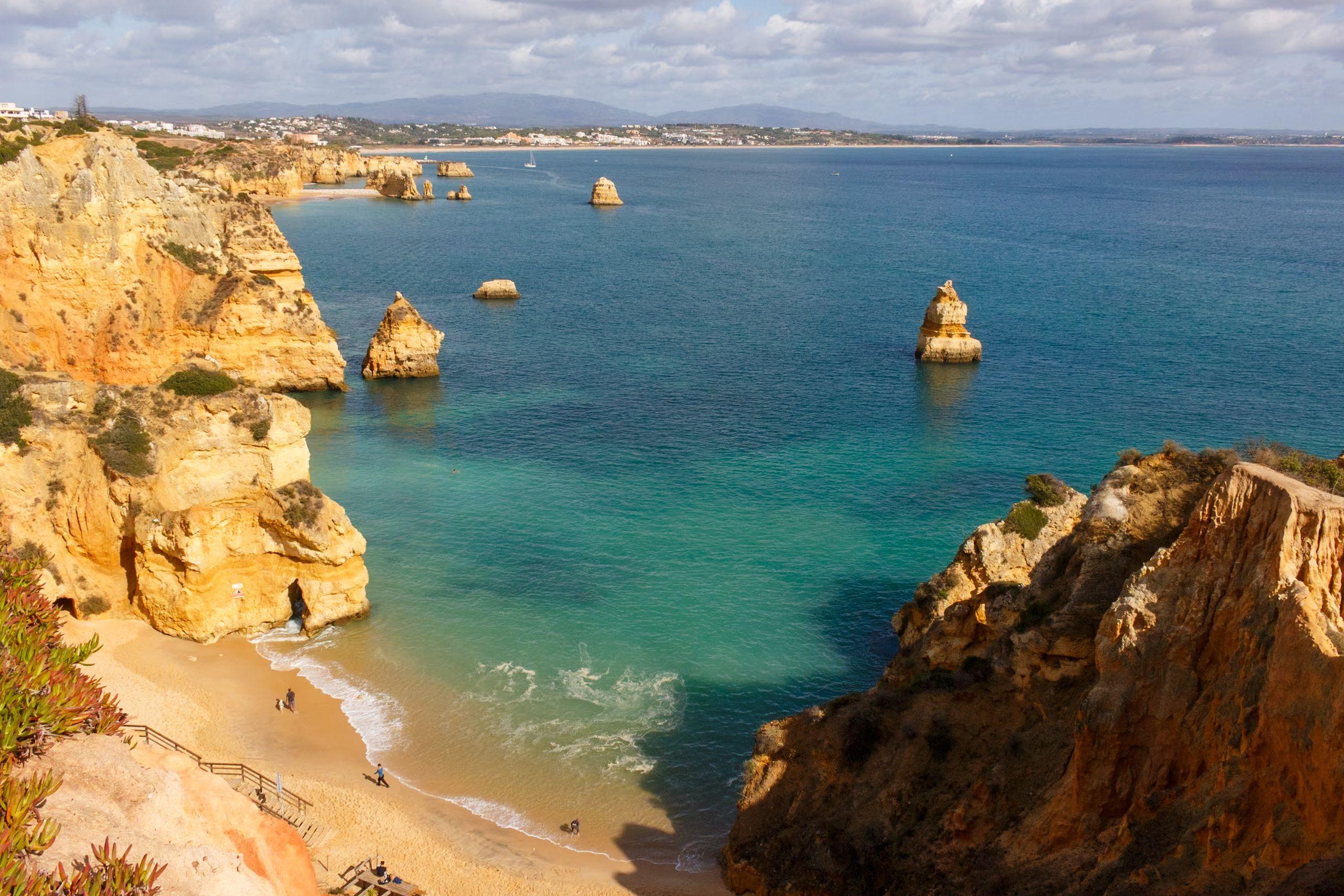 Beautiful aerial view of Praia do Camilo, Lagos, with golden cliffs and turquoise waters in Algarve, Portugal.