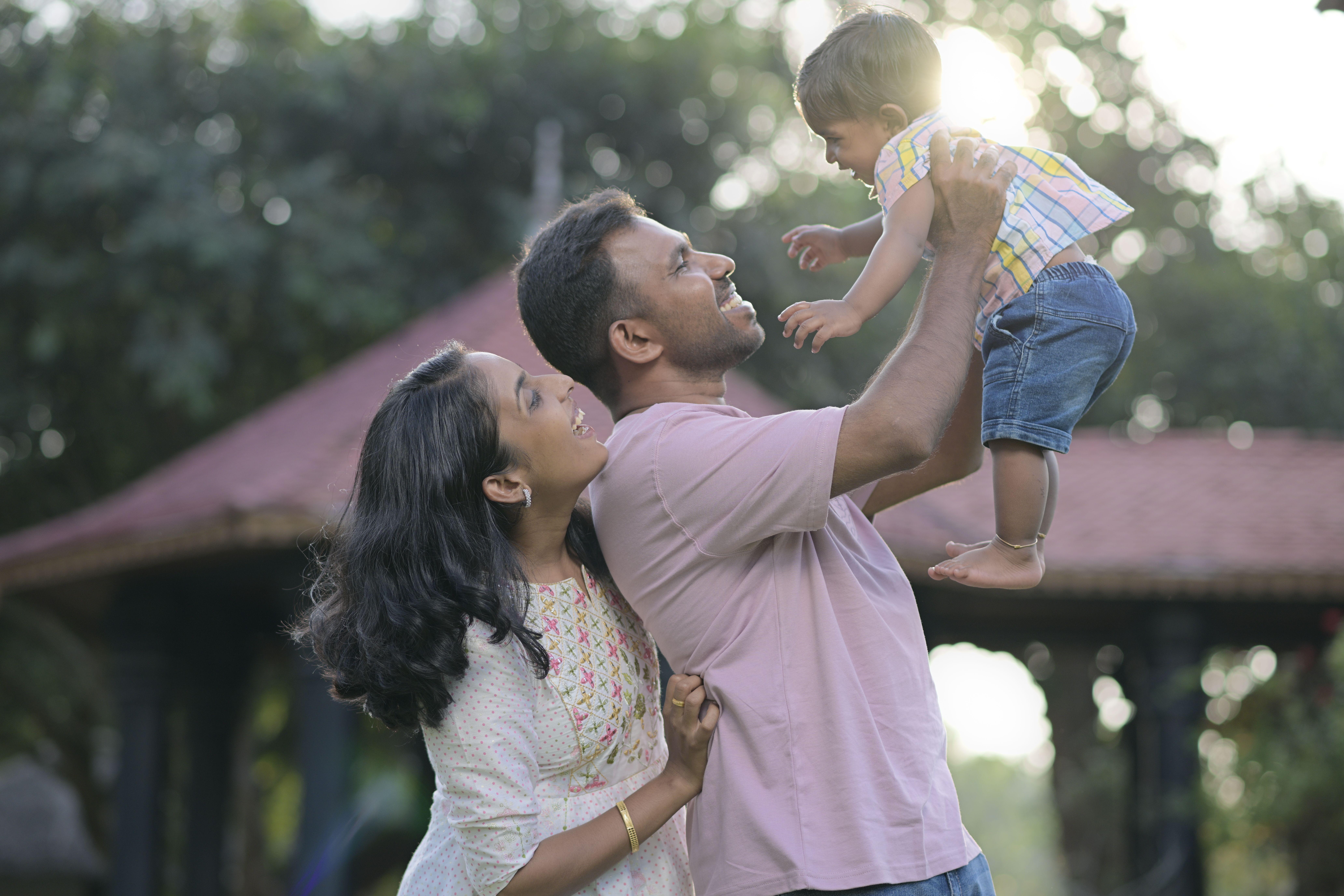 Happy family enjoying time together in a sunlit park, capturing love and joy.