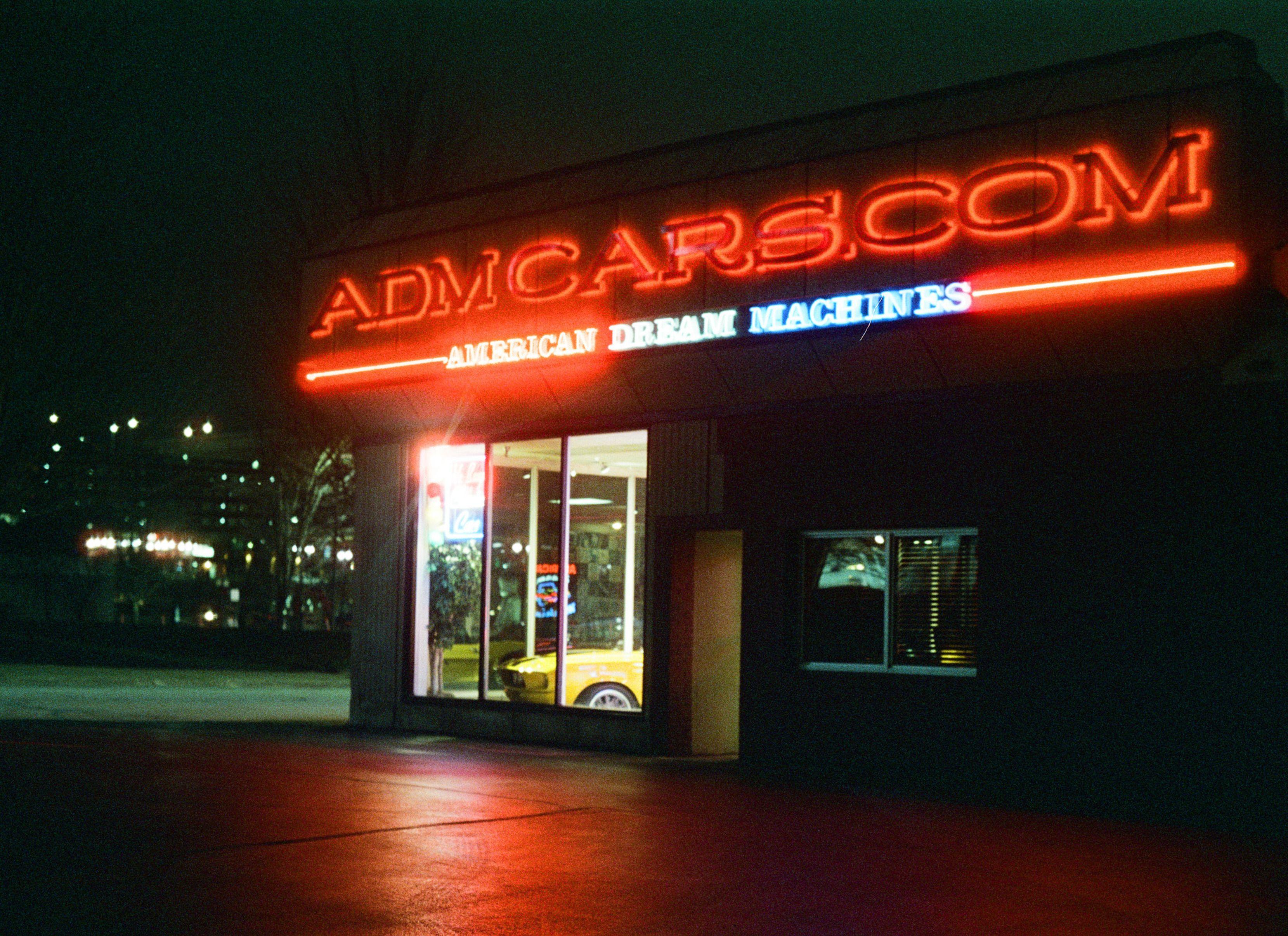 Night view of a neon-lit car dealership in Des Moines, Iowa, USA.