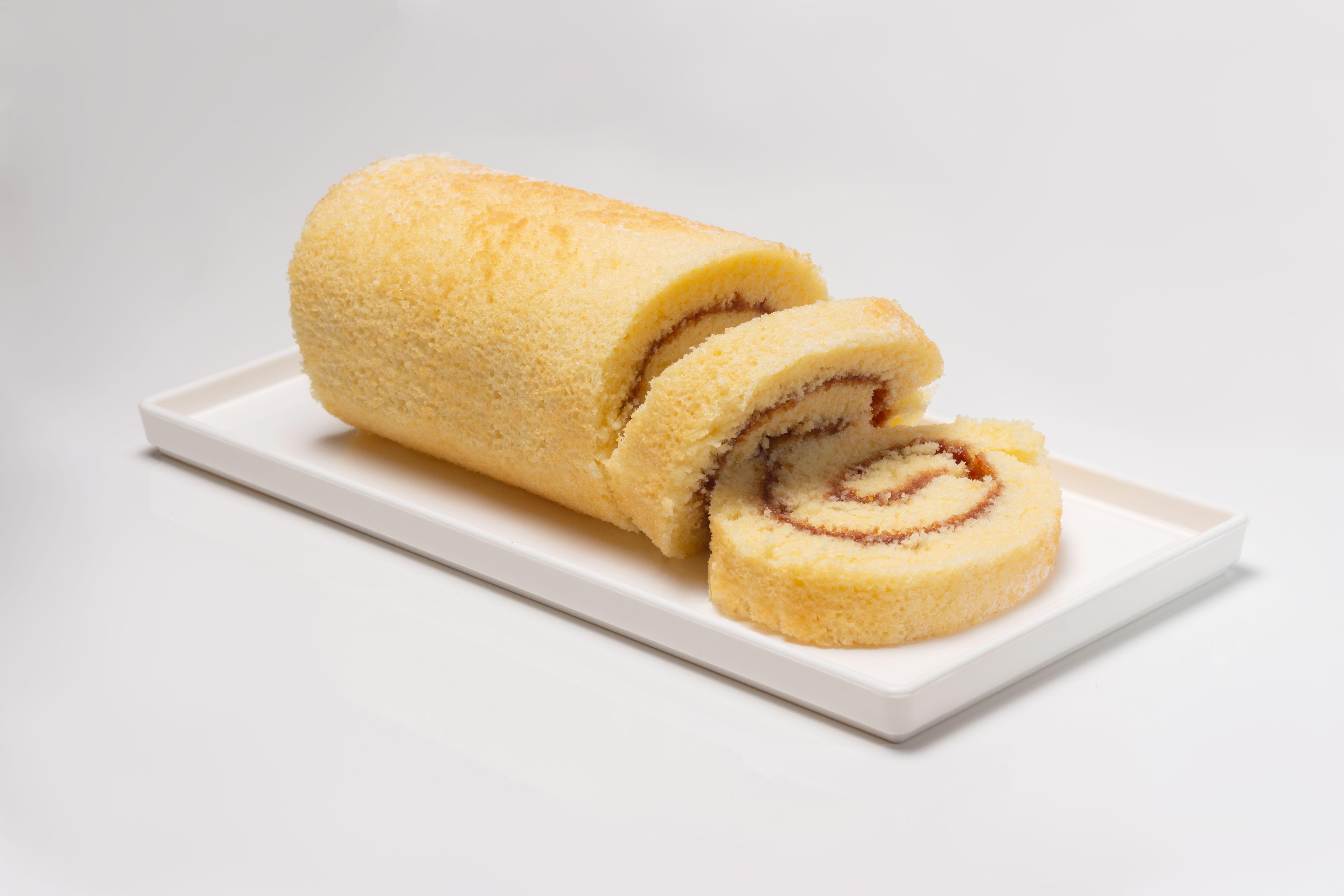 Close-up of a sweet and fluffy vanilla roll cake served on a plate.