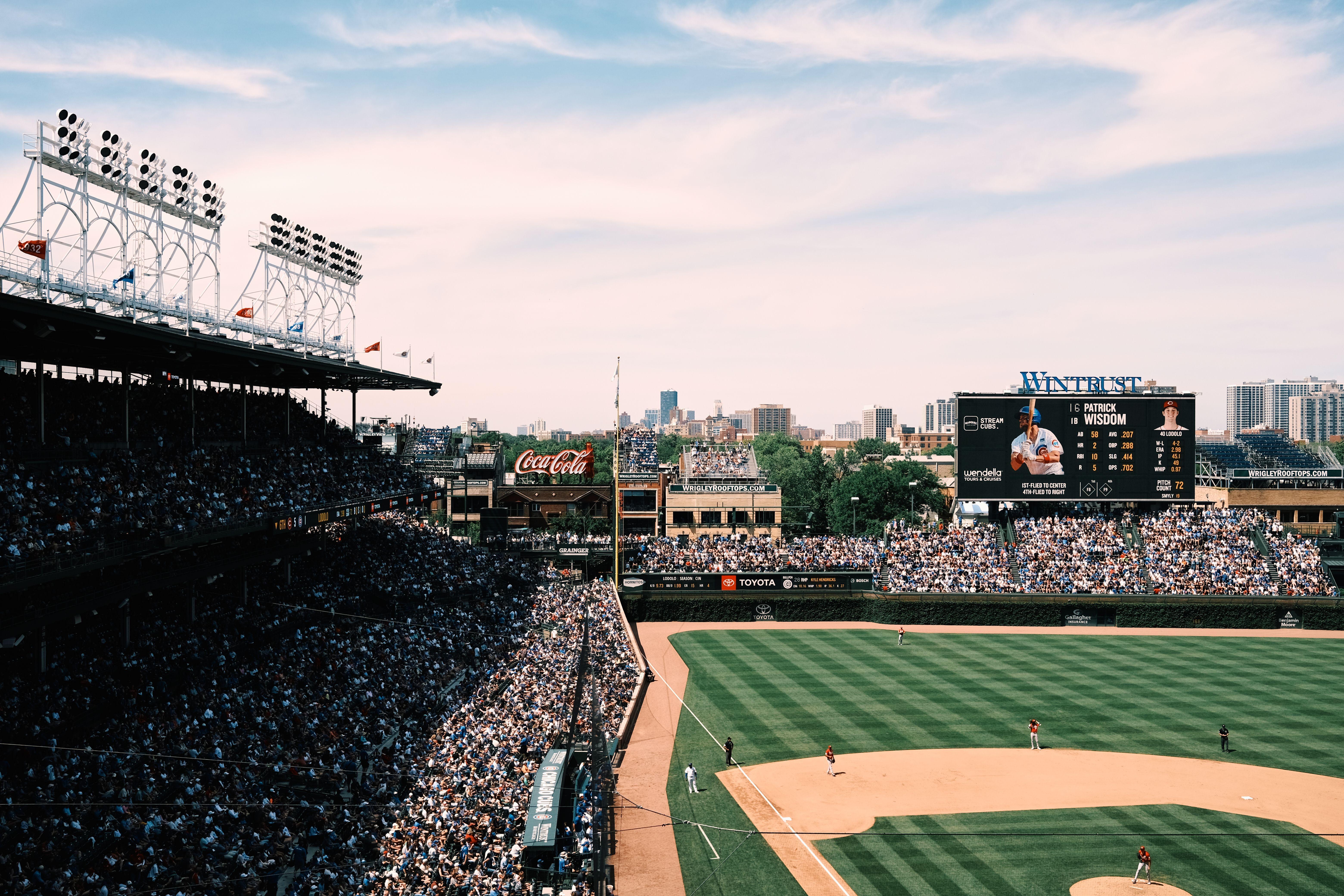 Aerial shot of a crowded baseball game at Wrigley Field, showcasing the vibrant cityscape of Chicago.