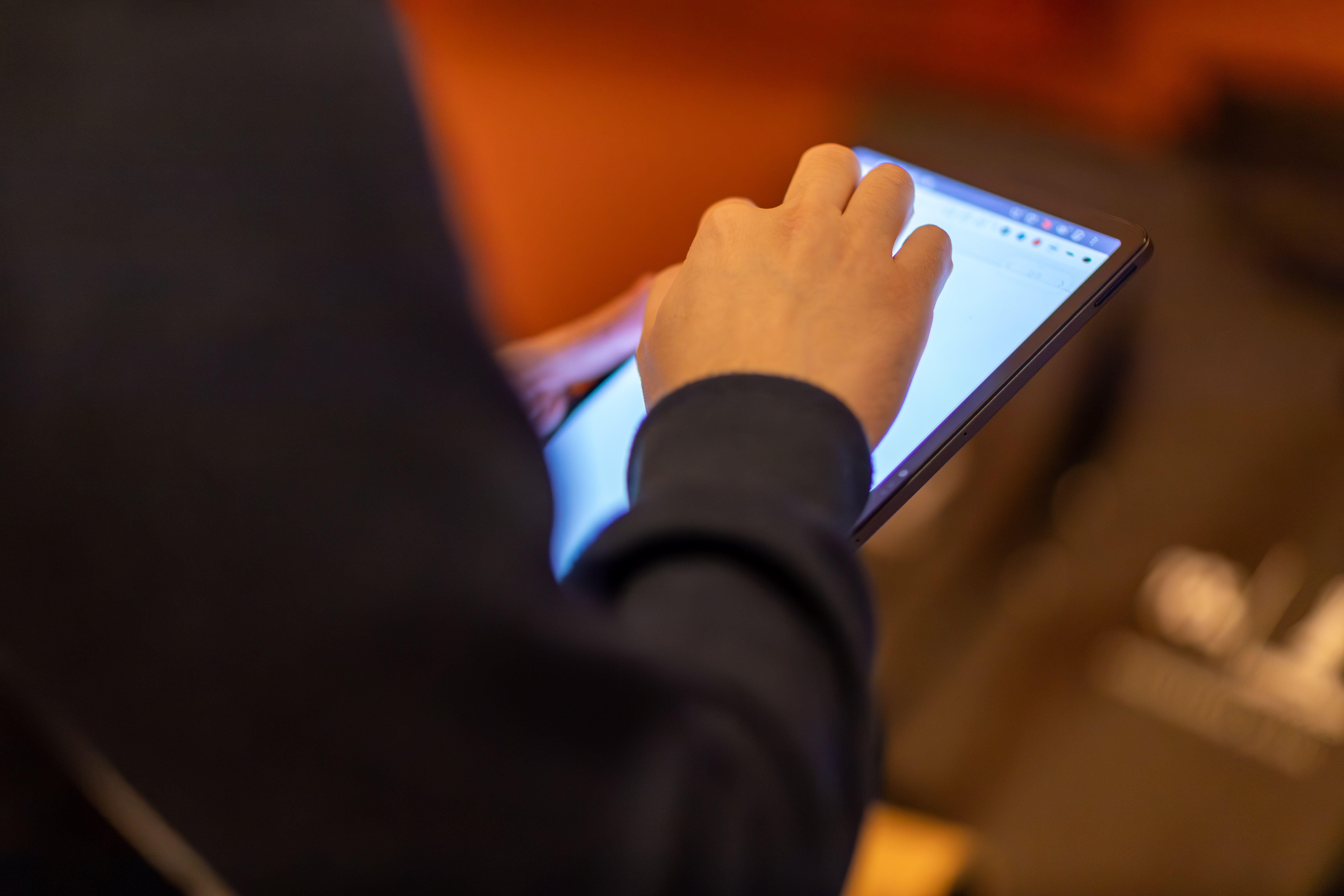 Close-up of a person using a tablet, showcasing technology and modern lifestyle.